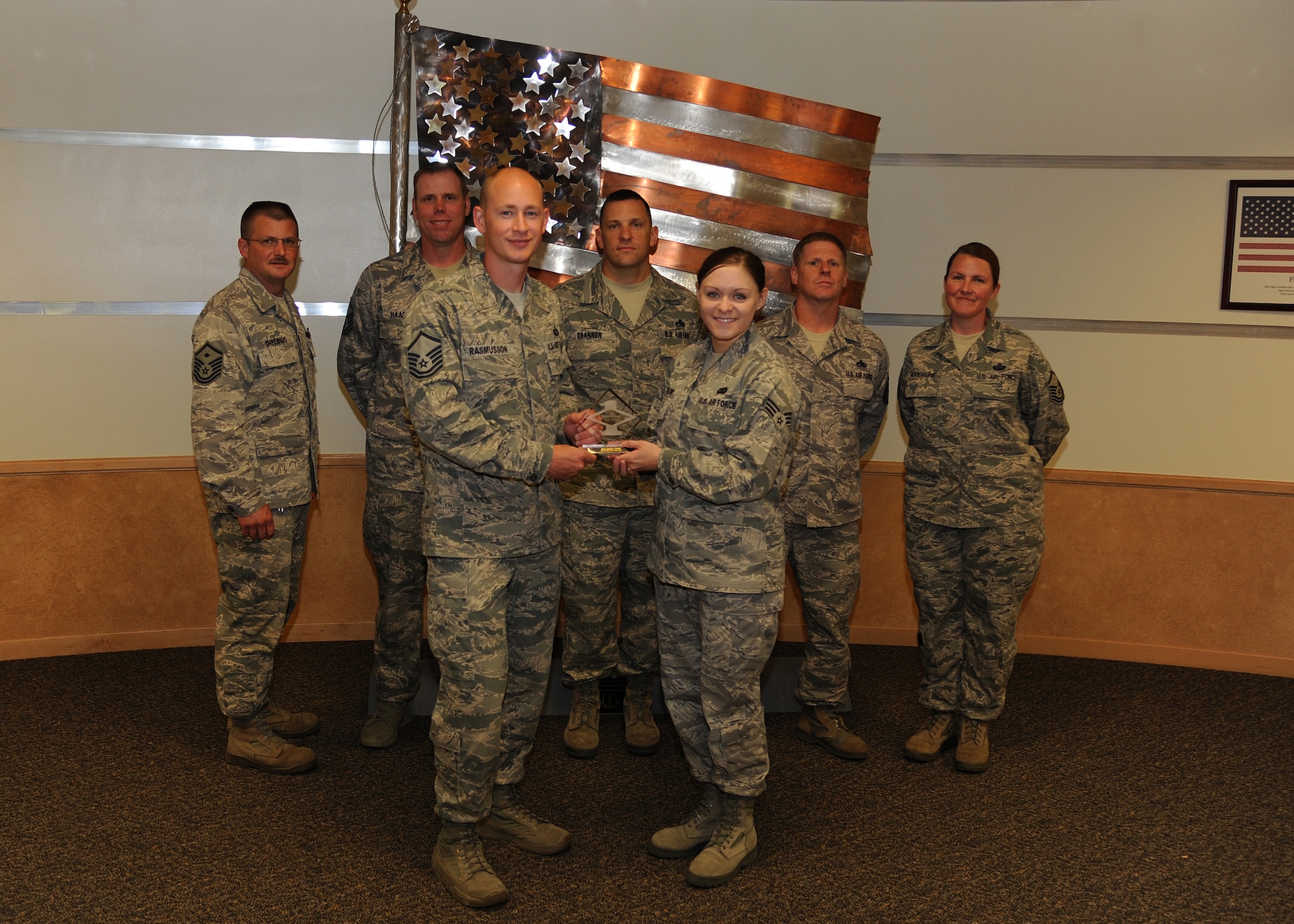 The 319th Communications Squadron’s first sergeant, Keelan Rasmusson, presents Senior Airman Ashley Taylor, 319th Air Base Wing Public Affairs photojournalist, with a Diamond Sharp Award Aug. 2, 2013, at Heritage Hall on Grand Forks Air Force Base, N.D. The Diamond Sharp Award is awarded to Airmen who epitomize service before self and strive for excellence at work and off duty. (U.S. Air Force photo/Airman 1st Class Zachiah Roberson)