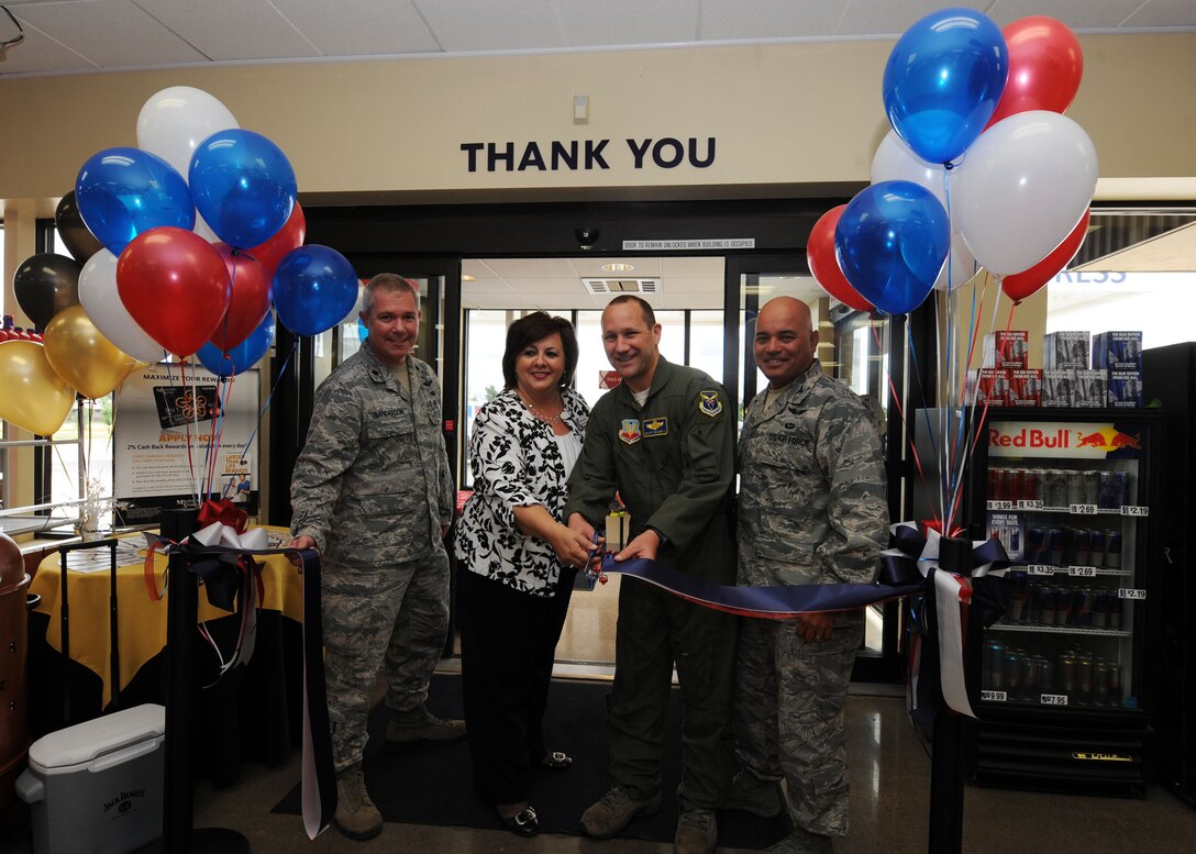 (Left) Lt. Col. Jason Sanderson, 28th Bomb Wing chief of security, Diana Krieger, Base Exchange Facilities general manager, Col. Gentry Boswell, 28th Bomb Wing vice commander, and Col. Thomas Goulter, 28th Mission Support Group commander, cut the ribbon commemorating the grand re-opening of the Express Shoppette at Ellsworth Air Force Base, S.D., Aug. 2, 2013. The $400,000, three month long renovation project created an updated look and allows for more efficient use of space which increases food and beverage options. (U.S. Air Force photo by Airman 1st Class Rebecca Imwalle/Released)