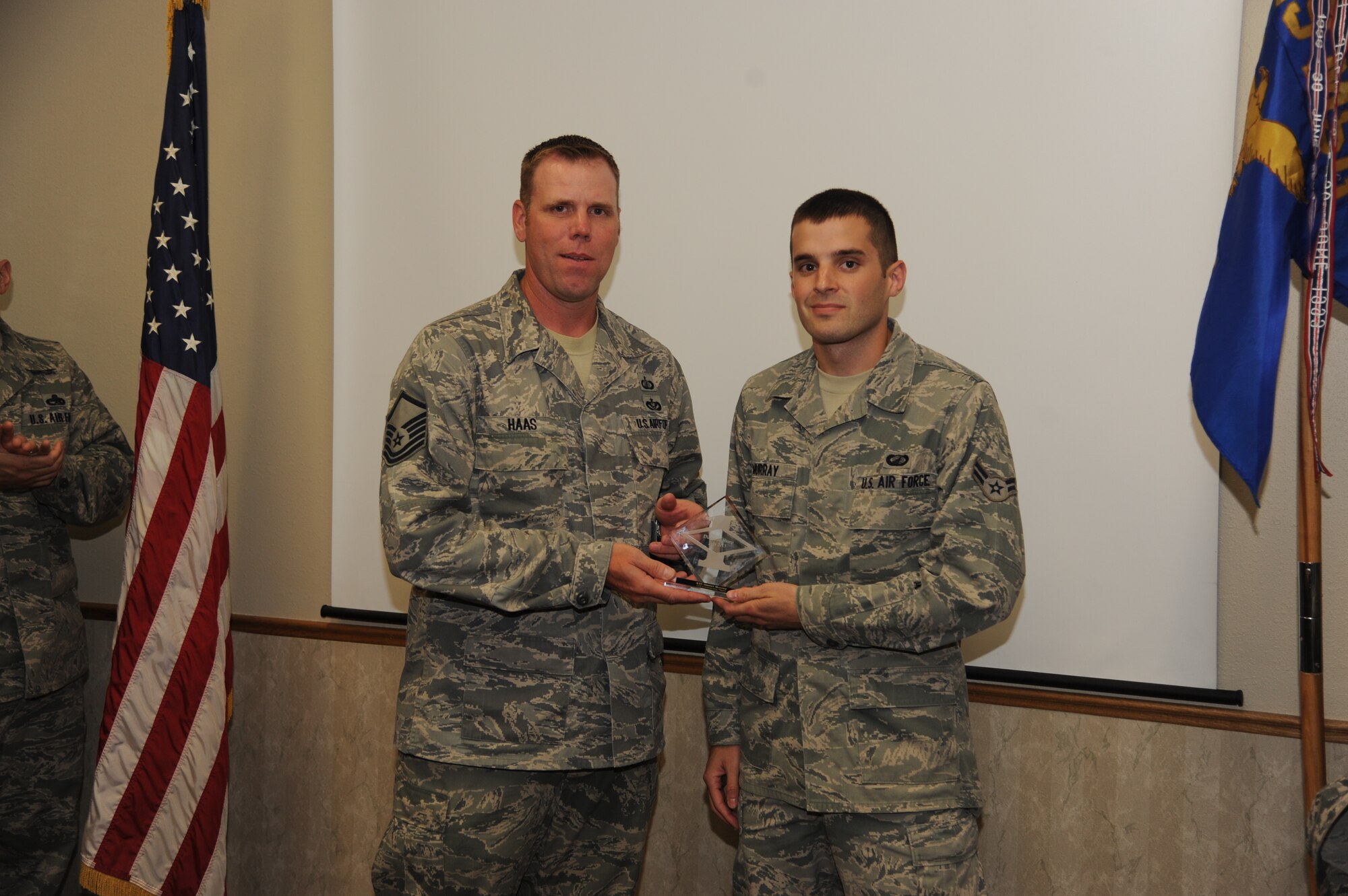 The 319th Contracting Flight’s first sergeant, Darrell Haas, presents Airman 1st Class Garrett Murray, 319th CONF contract specialist, with a Diamond Sharp Award Aug. 2, 2013, on Grand Forks Air Force Base, N.D. The Diamond Sharp Award is presented to Airmen who epitomize service before self and strive for excellence at work and off duty. (U.S. Air Force photo/Airman 1st Class Zachiah Roberson) Roberson)