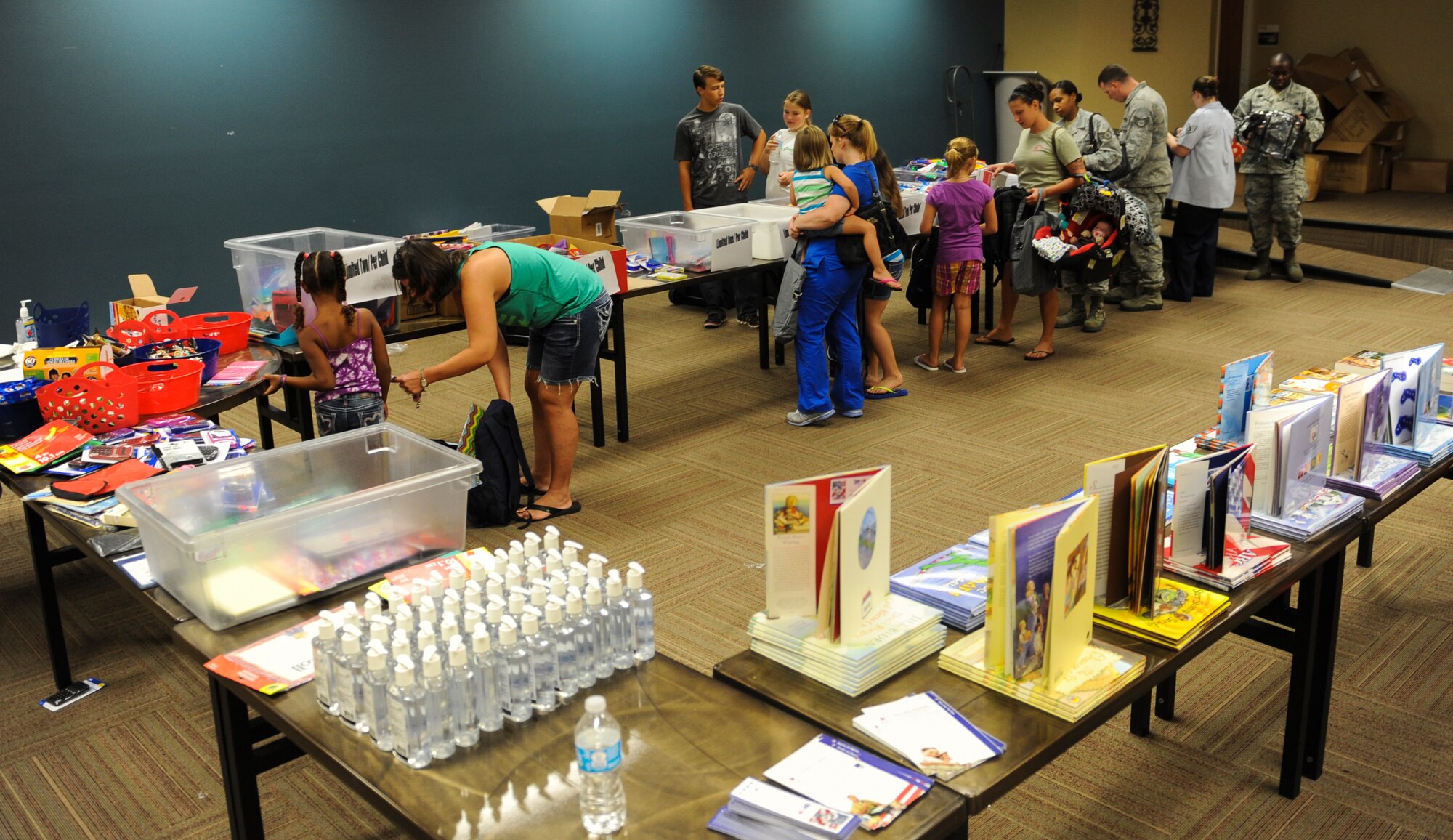 Members of Team Moody line up to receive school supplies for their school-aged children through the Operation Homefront program at Moody Air Force Base, Ga., Aug. 5, 2013. Operation Homefront, an organization that assists military families, has thus far helped 18,050 military children receive the supplies they need to start the school year off right. (U.S. Air Force photo by Airman Alexis Grotz/Released) 