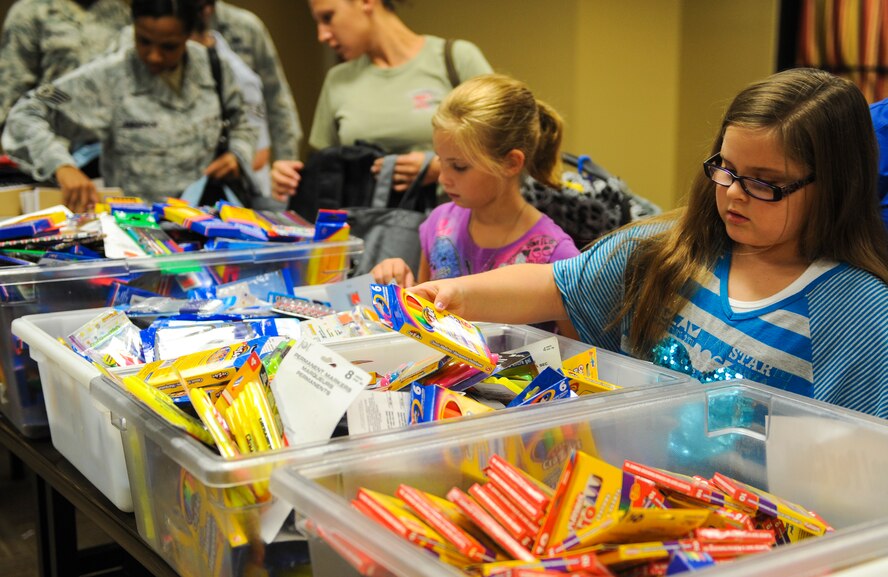 Children and parents pick out school supplies from many different tubs at Moody Air Force Base, Ga., Aug. 5, 2013. Military members wounded, ill, injured or ranked E-1 to E-6 with school age children were able to receive donated school supplies for their children through the Operation Homefront program. (U.S. Air Force photo by Airman Alexis Grotz/Released)