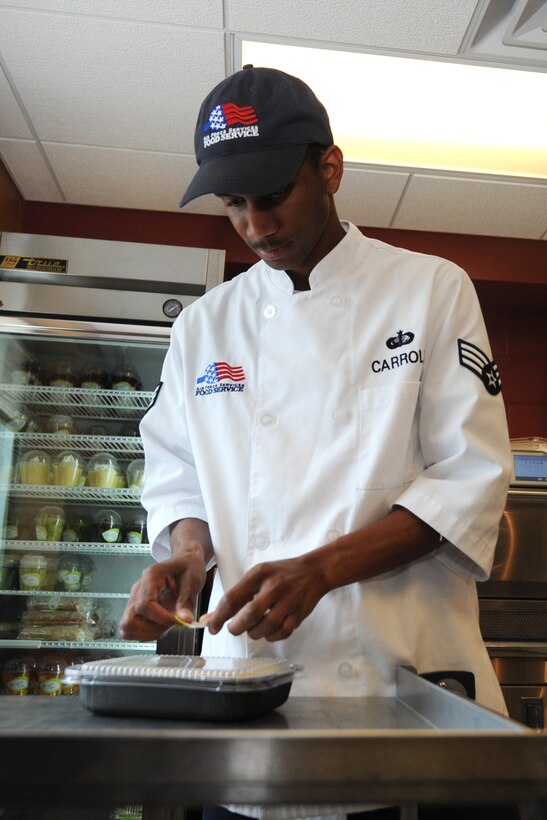 Senior Airman Rick Carroll, 28th Force Support Squadron food service technician, prepares meals at the new food kiosk in the 34th Bomb Squadron at Ellsworth Air Force Base, S.D., July 24, 2013. The kiosk is located within easy reach for flight line personnel and offers a variety of options for Airmen both on and off meal cards, to include two hot meal choices, cold subs, soup and an assortment of sides and snacks. (U.S. Air Force photo by Airman 1st Class Rebecca Imwalle/Released)