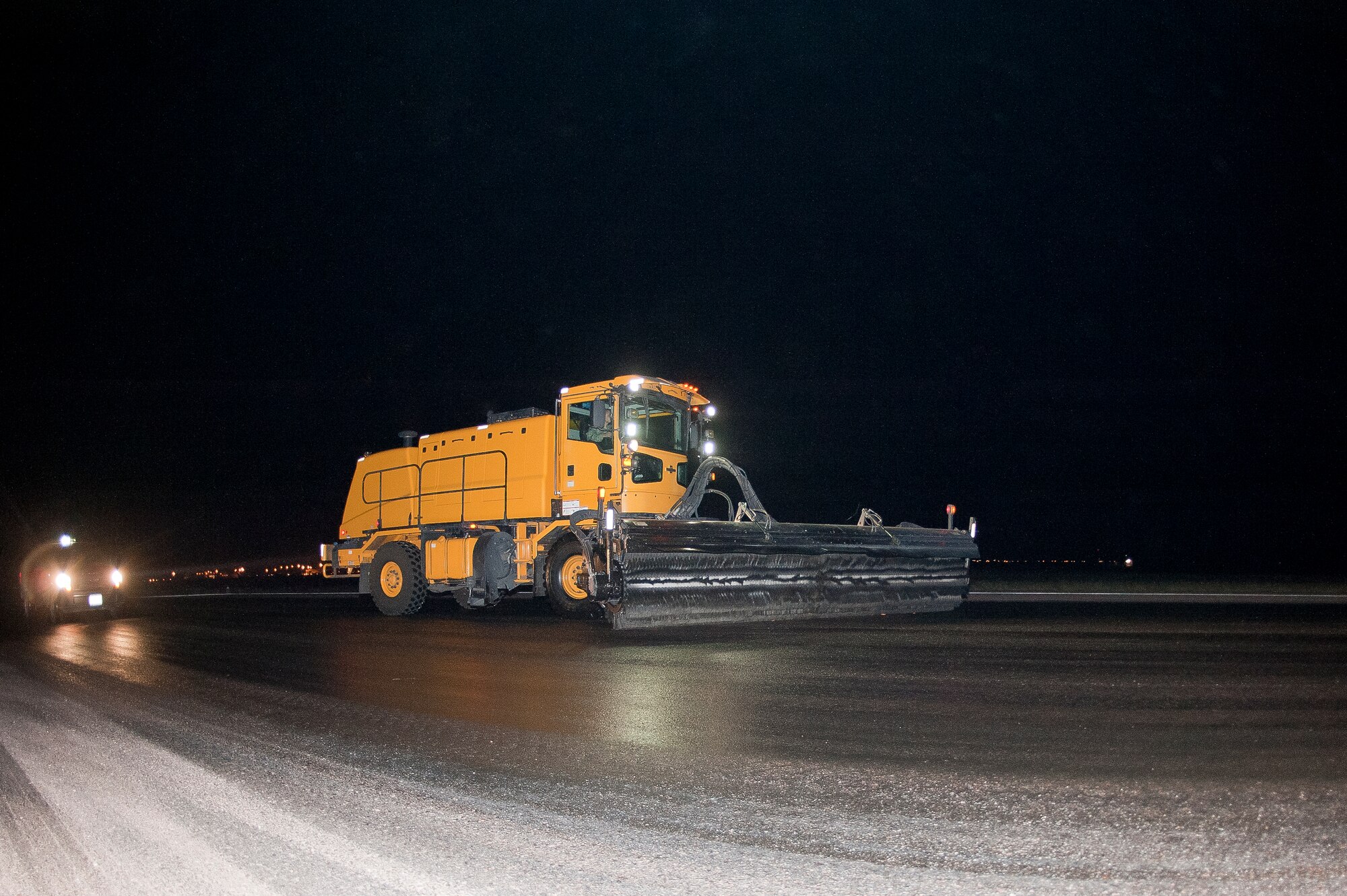 ALTUS AIR FORCE BASE, Okla. – U.S. Air Force Senior Airman Michael McCoy, 97th Civil Engineer Squadron pavement and heavy equipment operator, drives an Oshkosh street brush down the flighline during a rubber removal process, Aug. 2. The brush is driven over the affected areas of the runway for more than three hours to effectively pull up all impacted rubber on the runways. (U.S. Air Force photo by Senior Airman Dillon Davis/Released)