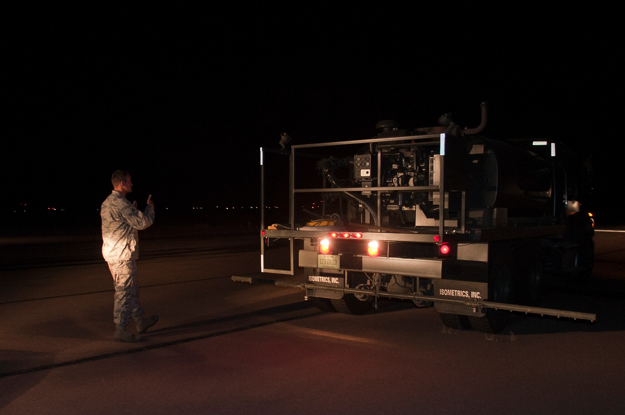 ALTUS AIR FORCE BASE, Okla. – U.S. Air Force Senior Airman Isaac Sutton, 97th Civil Engineer Squadron pavement and heavy equipment operator, guides a coworker into place before beginning rubber removal on the flightline here, Aug. 2. The 97th CES removes rubber from the flightline as needed to keep friction levels above the minimum to ensure safety for pilots and crew members. (U.S. Air Force photo by Senior Airman Dillon Davis/Released)