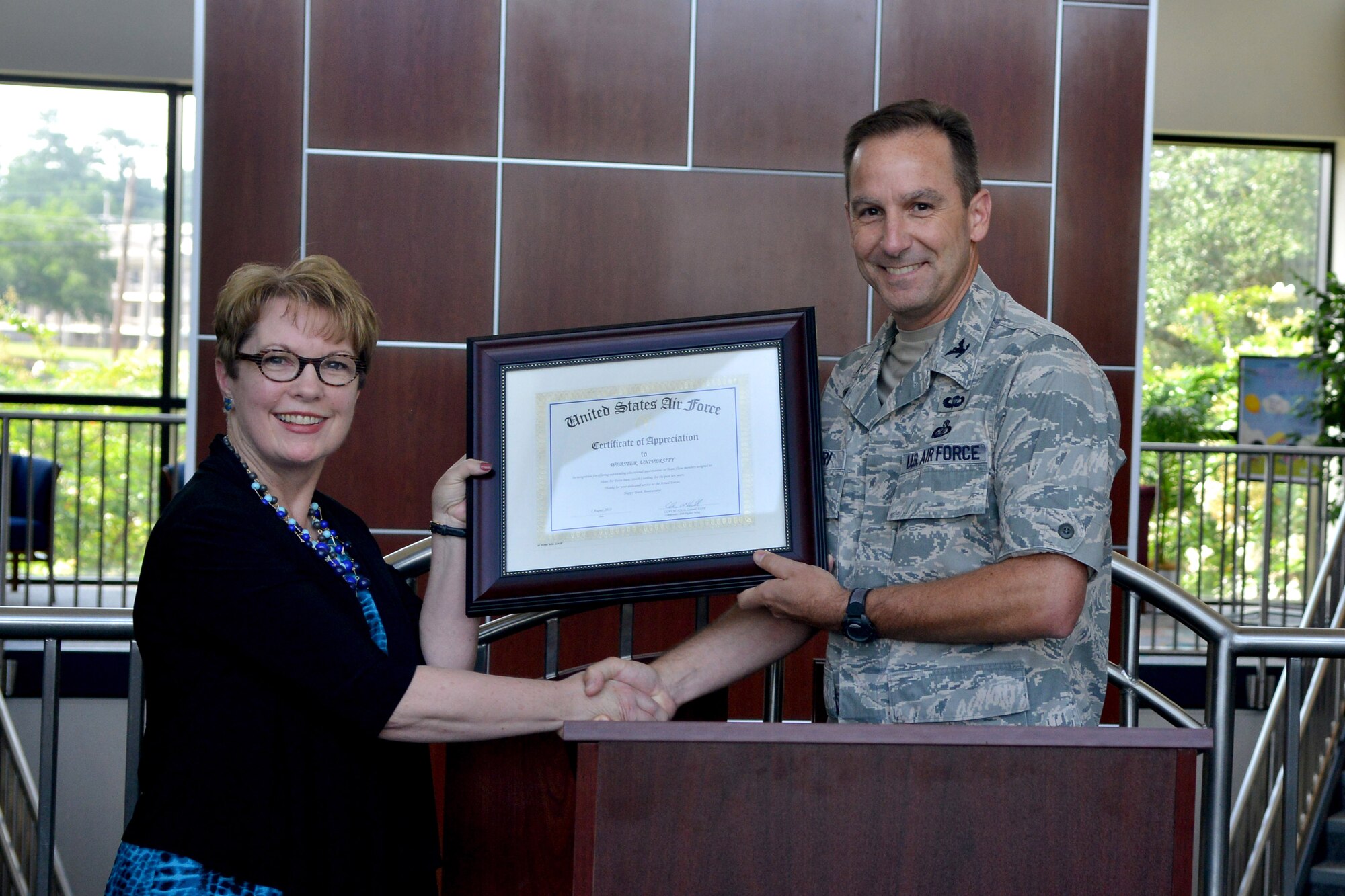 U.S. Air Force Col. Scott Arcuri, 20th Mission Support Group commander, presents Elizabeth Stroble, Webster University president, with her certificate of appreciation at Shaw Air Force Base, S.C., Aug. 1, 2013. Webster University has been on Shaw since March 2003. Webster University has graduated 313 individuals from Shaw with 36 honors alumni and 79 active-duty military members. (U.S. Air Force photo by Airman 1st Class Ashley L. Gardner/Released)