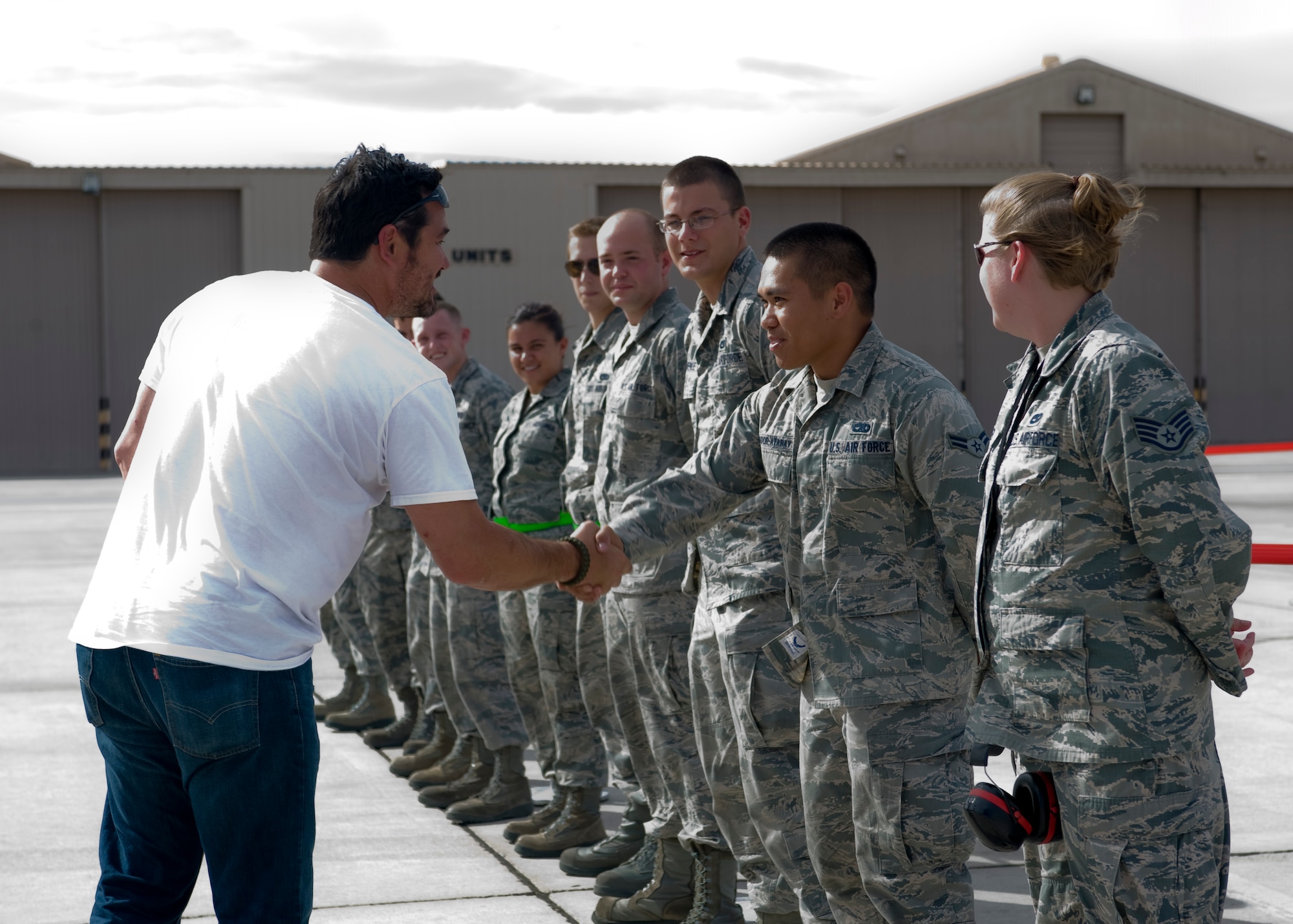 Actor Dean Cain shakes hands with Airmen from the 57th Aircraft Maintenance Squadron , Raptor Air craft Maintenance Unit, Aug. 2. 2013, at Nellis Air Force Base, Nev. Cain learned about the various capabilities of the F-22 Raptor and the various jobs Airmen perform to keep the aircraft in working condition. The F-22 Raptor is a single-seat, twin-engine, fifth- generation, maneuverable fighter aircraft that uses stealth technology designed primarily as an air superiority fighter but has additional capabilities that include ground attack, electronic warfare, and signals intelligence roles. (U.S. Air Force photo by Airman 1st Class Jason Couillard)