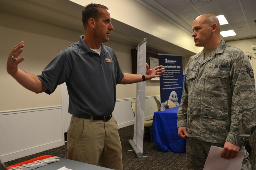 U.S. Air Force Staff Sgt. Paul Kelso, 20th Logistics Readiness Squadron inbound freight supervisor, listens as Kelly Farrington, Penhall Company military liaison, describes his job during the 20th Force Support Squadron job fair, Shaw Air Force Base, S.C., Aug. 2, 2013. The personnel manning each booth were available to speak  about open job positions within the organizations they represented. . (U.S. Air Force photo by Airman 1st Class Ashley L. Gardner/Released)