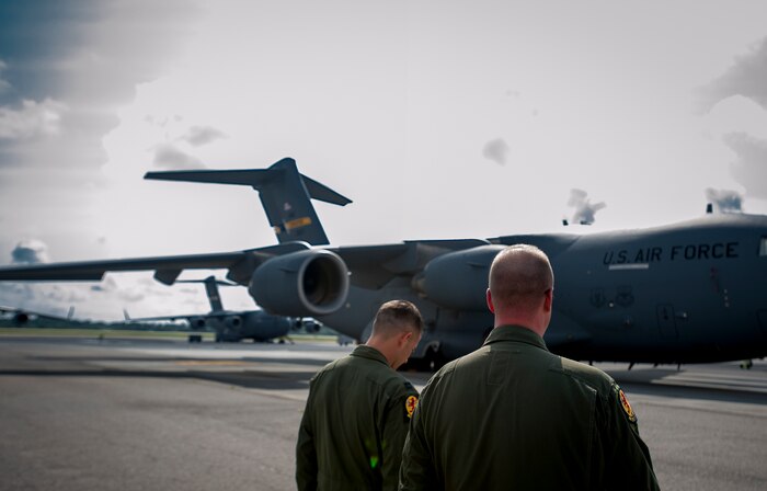 Capt. Paul Geunther (left), 16th Airlift Squadron C-17 pilot, and Master Sgt. Aaron Avery, 16th AS standards and evaluations superintendent, walk along the flight line July 30, 2013,  at Joint Base Charleston – Air Base, S.C.  They’ve both dedicated their career to traveling the world inside a C-17 Globemaster III. JB Charleston is scheduled to receive the final C-17 Sept. 12, 2013, as Boeing completes work on the U.S. Air Force’s last Globemaster. The first C-17 to enter the Air Force’s inventory arrived at Charleston Air Force Base in June 1993. The C-17 is capable of rapid strategic delivery of troops and all types of cargo to main operating bases or directly to forward bases in the deployment area.
(U.S. Air Force photo / Airman 1st Class Tom Brading)
