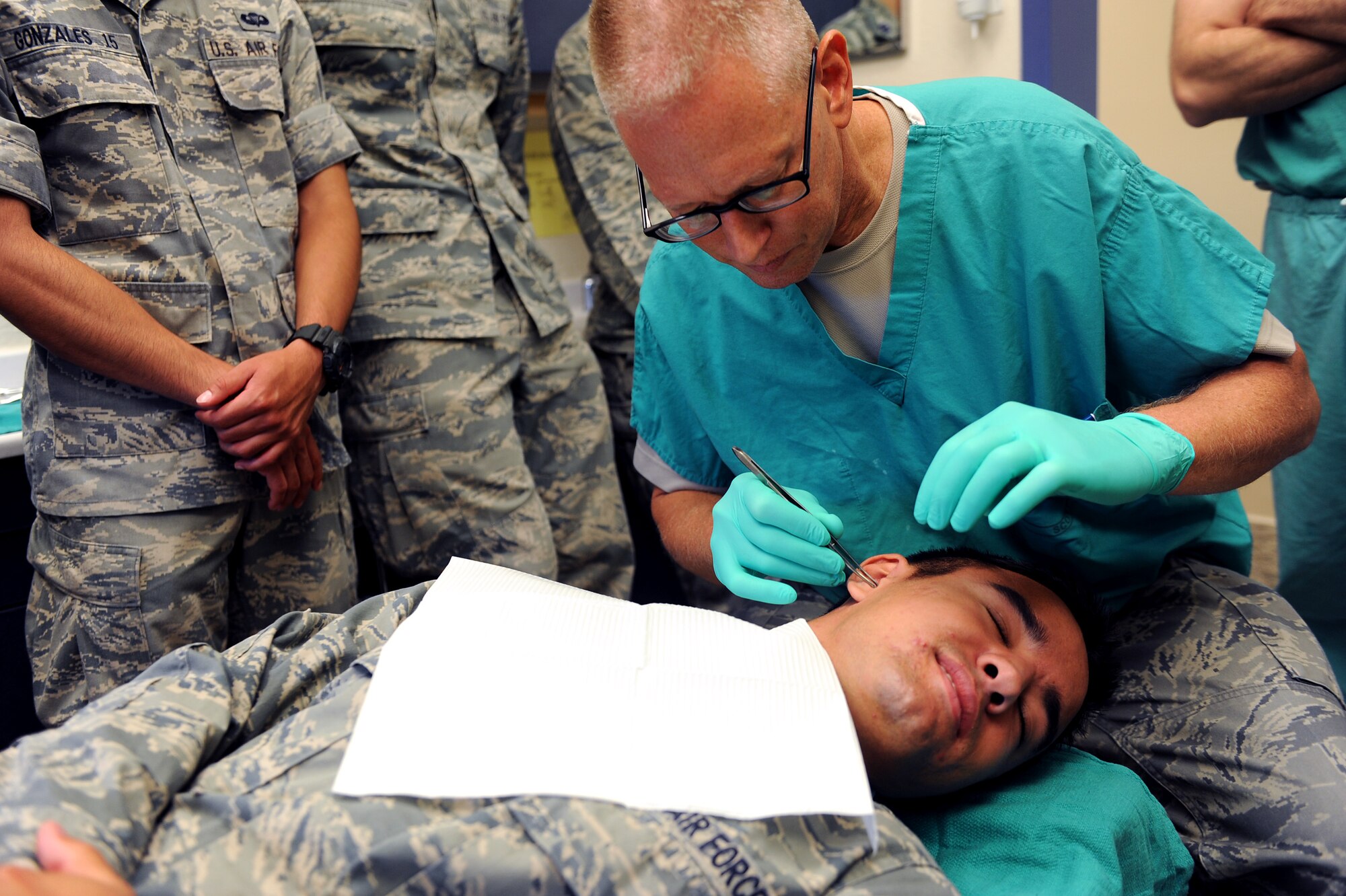 United States Air Force Academy cadet Taylor Klinkmann, has cotton placed in his ear by Lieutenant Col. David Pierson, 375th Dental Squadron prosthodontics, July 26, 2013 at Scott Air Force Base, Ill. The cotton is placed in the ear as preparation for the extrude used for ear impressions. The cadets visited different squadrons on base to get a feel of the everyday jobs of the Air Force. (U.S. Air Force photo/Airman 1st Class Jaeda Waffer)