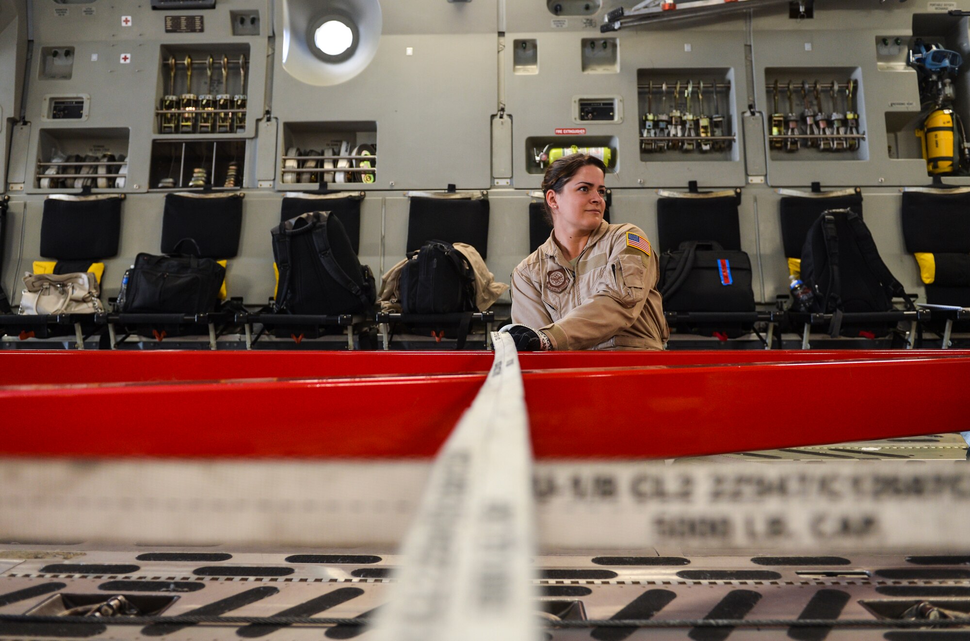 Senior Airman Desiree Lemus, 21st Airlift Squadron loadmaster and native of Homestead, Fla., ratchets cargo equipment into place inside a C-17 Globemaster III Aug. 2, 2013, at Buckley Air Force Base, Colo. The crewmembers aboard the C-17, which includes four pilots, two loadmasters and one crew chief, flew the spacecraft to its final destination at the Kennedy Space Center. (U.S. Air Force photo by Staff Sgt. Paul Labbe/Released)