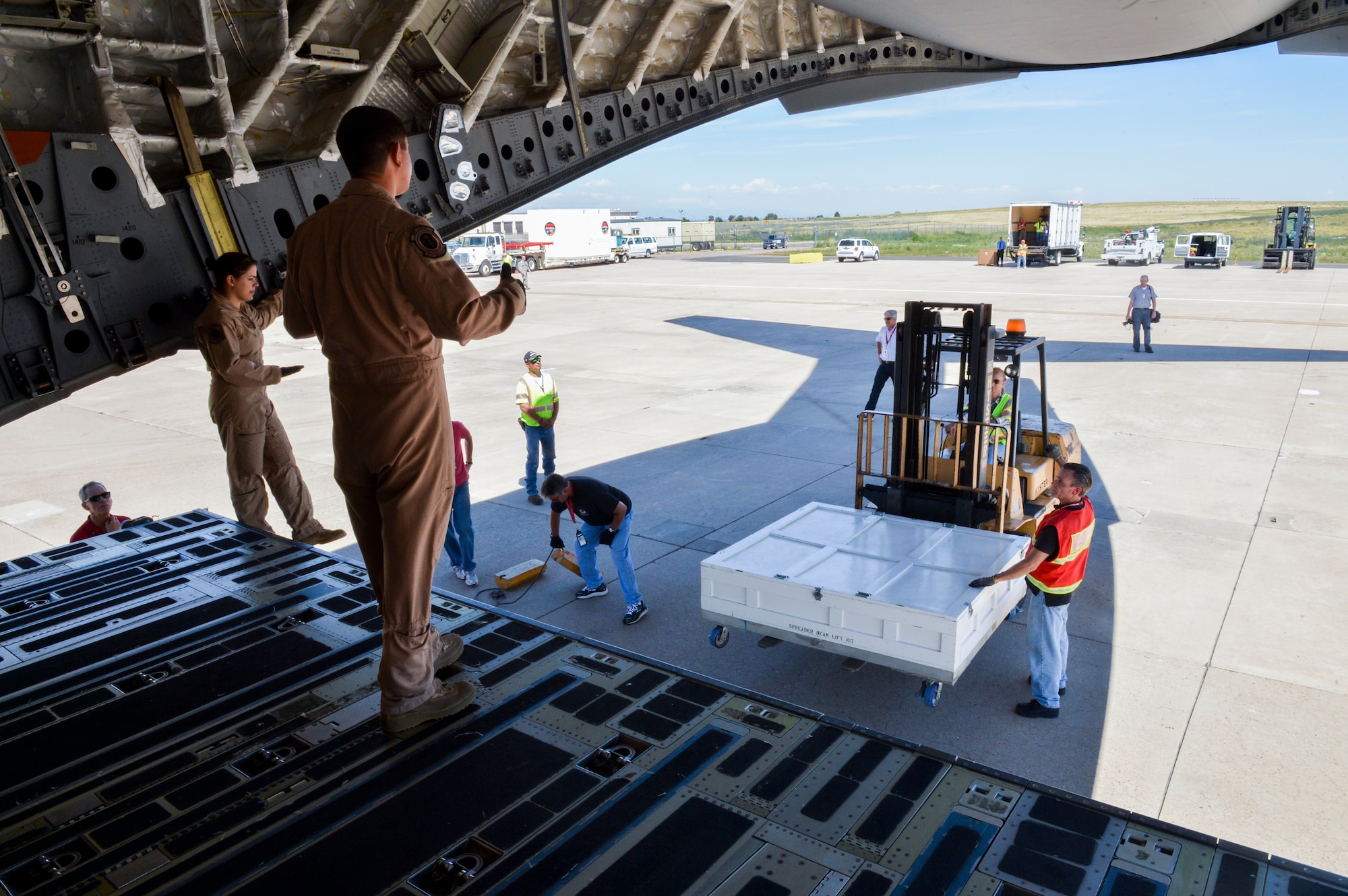 Senior Airman Desiree Lemus, 21st Airlift Squadron loadmaster and native of Homestead, Fla., left, and Tech. Sgt. Patrick Bloom, 21st AS loadmaster and native of Highlands Ranch, Colo., direct the movement of parts of the Mars Atmosphere and Volatile Evolution Mission spacecraft Aug. 2, 2013, at Buckley Air Force Base, Colo. The MAVEN spacecraft’s goal is to make measurements that will determine the history of the Martian atmosphere. (U.S. Air Force photo by Staff Sgt. Paul Labbe/Released)