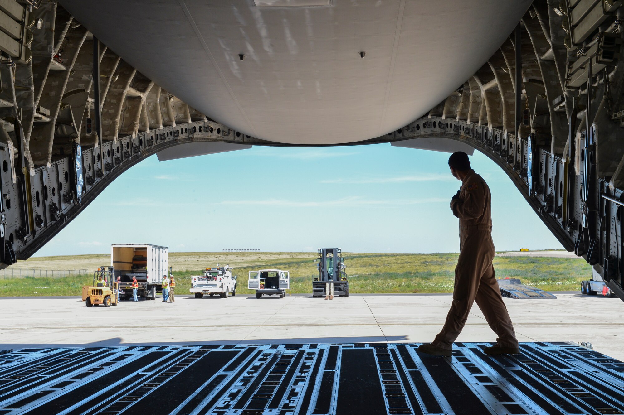 Tech. Sgt. Patrick Bloom, 21st Airlift Squadron loadmaster, a native of Highlands Ranch, Colo., walks across the back of a C-17 Globemaster III Aug. 2, 2013, at Buckley Air Force Base, Colo. Military members worked alongside NASA Goddard and Lockheed Martin representatives to load the Mars Atmosphere and Volatile Evolution Mission spacecraft into the C-17 to be shipped to the Kennedy Space Center. (U.S. Air Force photo by Staff Sgt. Paul Labbe/Released) 