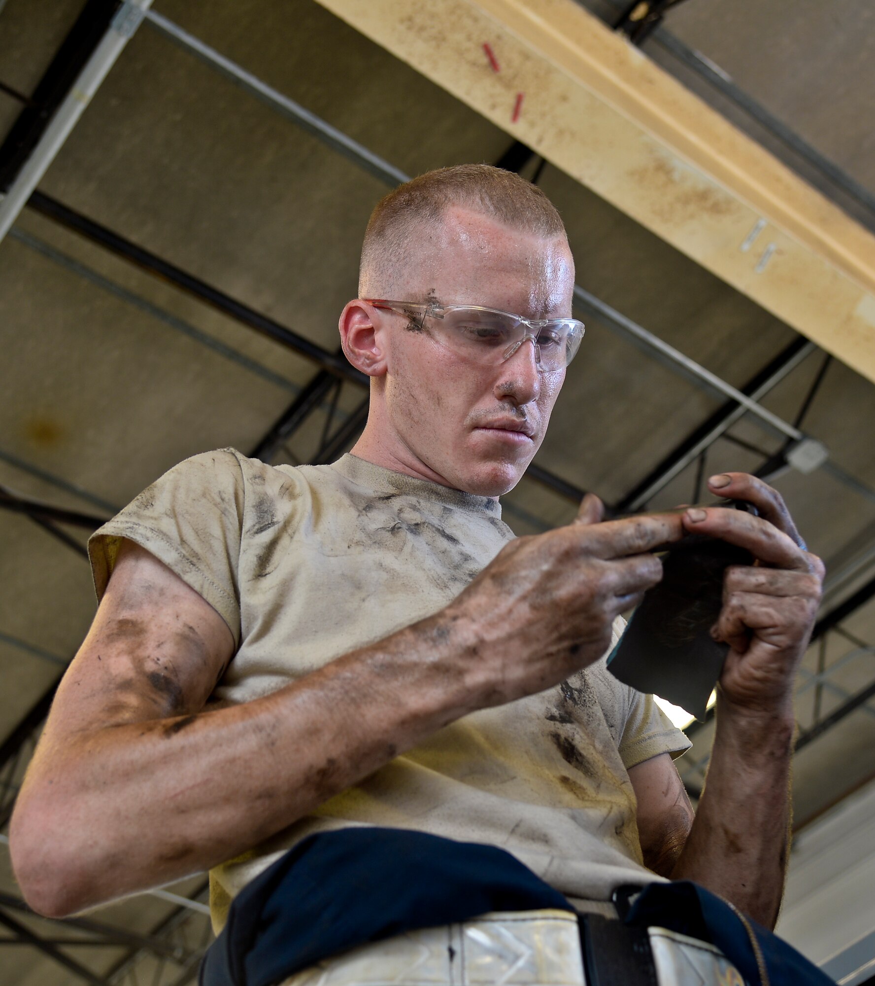 Airman 1st Class Michael Watkins, 6th Maintenance Squadron aerospace ground equipment technician, files a linkage pin for a Hobart power unit tow-bar at MacDill Air Force Base on Aug 5, 2013. The 6th MXS AGE shop is in charge of more than 290 pieces of maintenance and flight operations critical equipment. (U.S. Air Force photo by Staff Sgt. Brandon Shapiro)