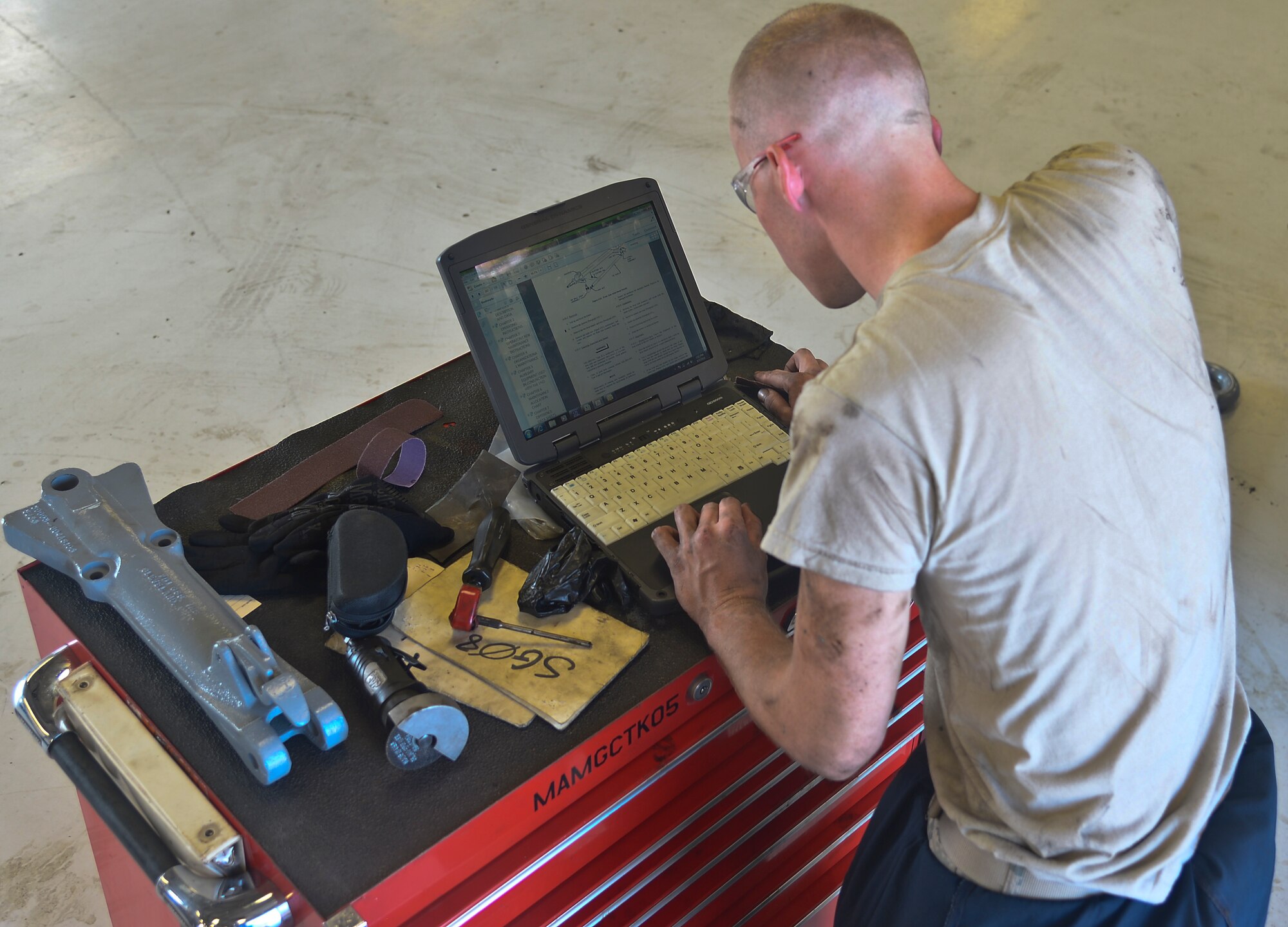 Airman 1st Class Michael Watkins, 6th Maintenance Squadron aerospace ground equipment technician, refers to his digital technical order during repairs to a Hobart power unit tow-bar at MacDill Air Force Base, Fla. on Aug 5, 2013. The 6th MXS AGE shop is in charge of more than 290 pieces of maintenance and flight operations critical equipment. (U.S. Air Force photo by Staff Sgt. Brandon Shapiro)