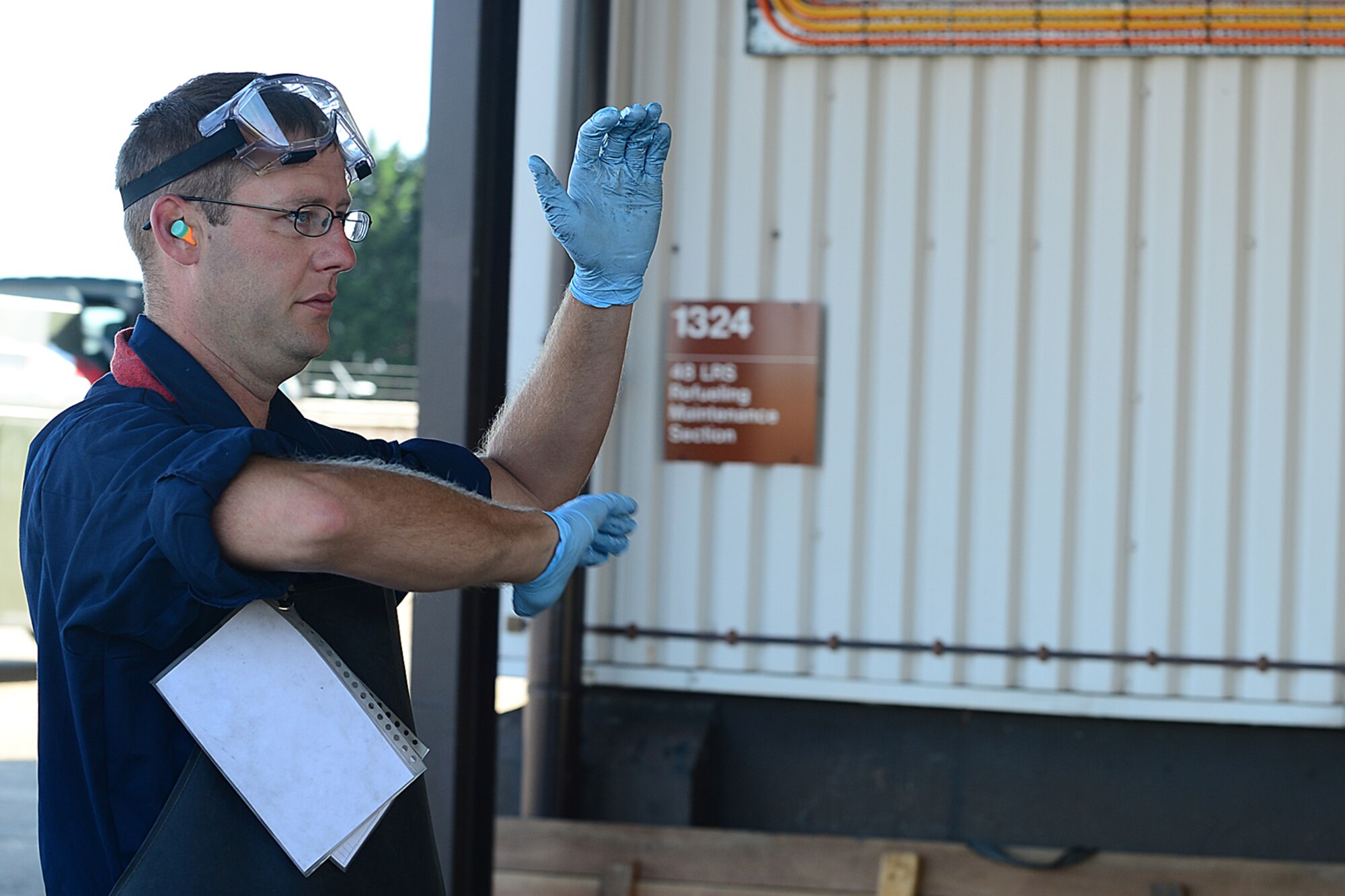 Senior Airman Vernoy Tate, 48th Logistics Readiness Squadron fuels technician, motions for an R-11 refueling truck to pull forward while performing a checkpoint inspection during a Logistics Compliance Assessment Program inspection at Royal Air Force Lakenheath, England, August 6, 2013. The LCAP is held bi-annually to ensure all logistics and maintenance squadrons are able to perform key logistics processes in a compliant manner. (U.S. Air Force photo by Airman 1st Class Dana J. Butler/Released)