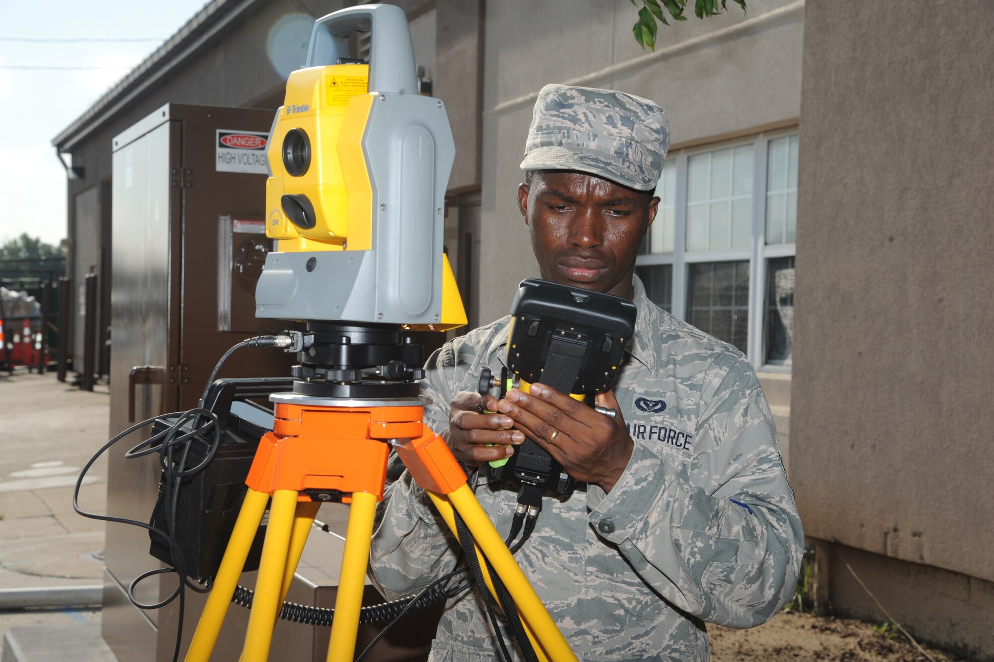 Airman 1st Class Samuel Nyamekye, 22nd Civil Engineering Squadron engineering assistant, uses a total station controller to accurately measure four corners of a building July 31, 2013, at McConnell Air Force Base, Kan. The buildings were originally mapped through satellite imagery but are re-measured by a surveying team for additional accuracy. Nyamekye enlisted in the Air Force to support his family living in the Republic of Ghana. (U.S. Air Force photo/Airman 1st Class John Linzmeier)