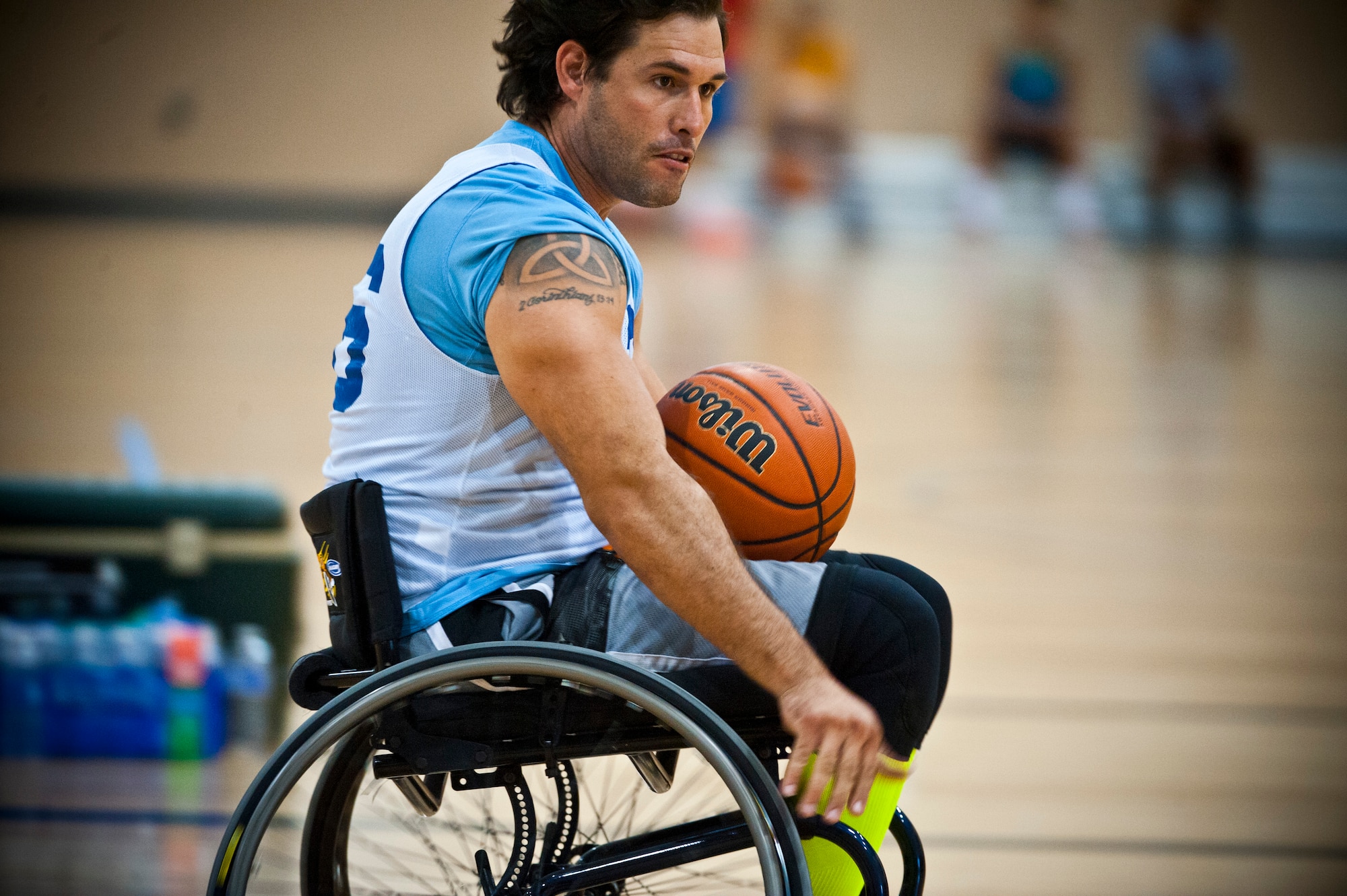Ryan Pinnie, an adaptive sports camp participant, looks for a teammate to pass to during a wheelchair basketball scrimmage at an Air Force Wounded Warrior Adaptive Sports Camp July 31, 2013, held at the Warrior Fitness Center at Nellis Air Force Base, Nev. More than 30 Air Force wounded warriors attended the two-day adaptive sports camp featuring wheelchair basketball, sitting volleyball, yoga, swimming, air rifle/pistol shooting and track and field designed to help them overcome their challenges and enjoy an active lifestyle. (U.S. Air Force photo/Senior Airman Brett Clashman)