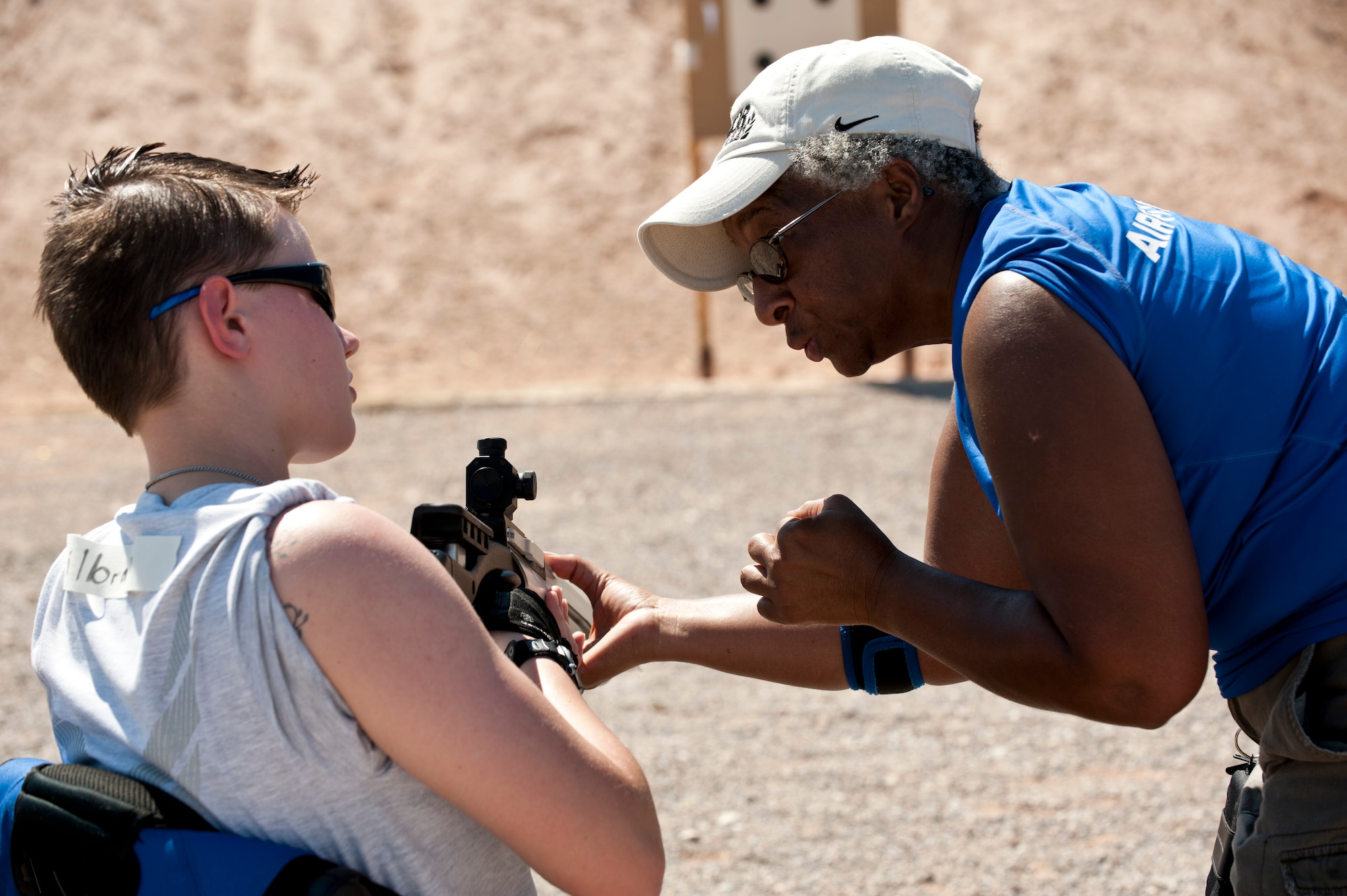 Gwen Sheppard, a member of the Air Force Wounded Warrior Air Rifle and Archery teams, mentors Haley Gilbraith, 315th Training Squadron imagery analyst out of Goodfellow Air Force Base, Texas, on the airsoft rifle during the Air Force Wounded Warrior Adaptive Sports Camp July 31, 2013, at Nellis AFB, Nev. Gilbraith was participating in the three day Air Force Wounded Warrior Adaptive Sports Camp event which offered a variety of sports clinics to service members from across the country. (U.S. Air Force photo by Caitlin Kenney)