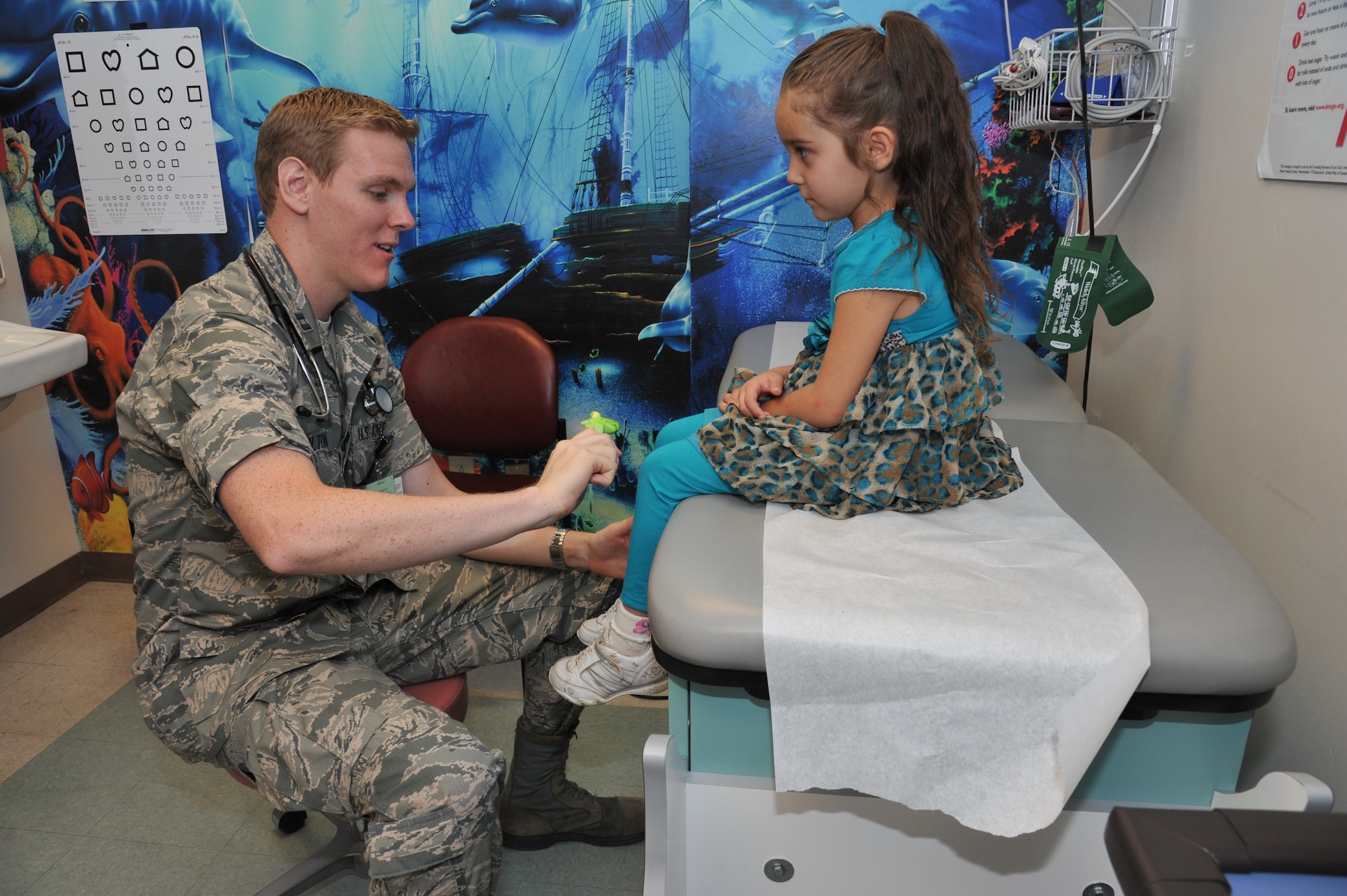 Capt. (Dr.) Robert Bolten works with a young patient, Alina Luna. Bolton is one of three new health care providers at the 377th Medical Group's Pediatric Clinic. (Photo by Ken Moore)
