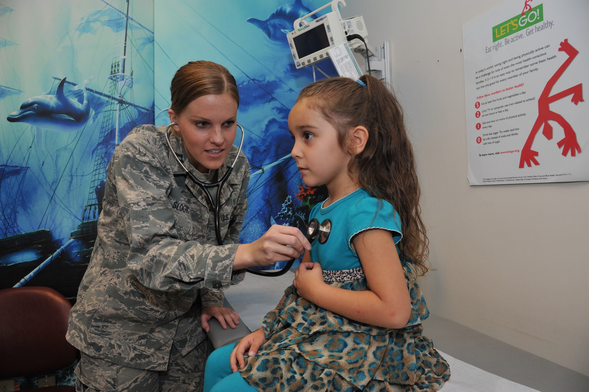 Capt. (Dr.) Rebecca Slogic listens to Alina Luna’s heartbeat. Slogic is one of the three new health care providers at the 377th Medical Group Pediatric Clinic. (Photo by Ken Moore)