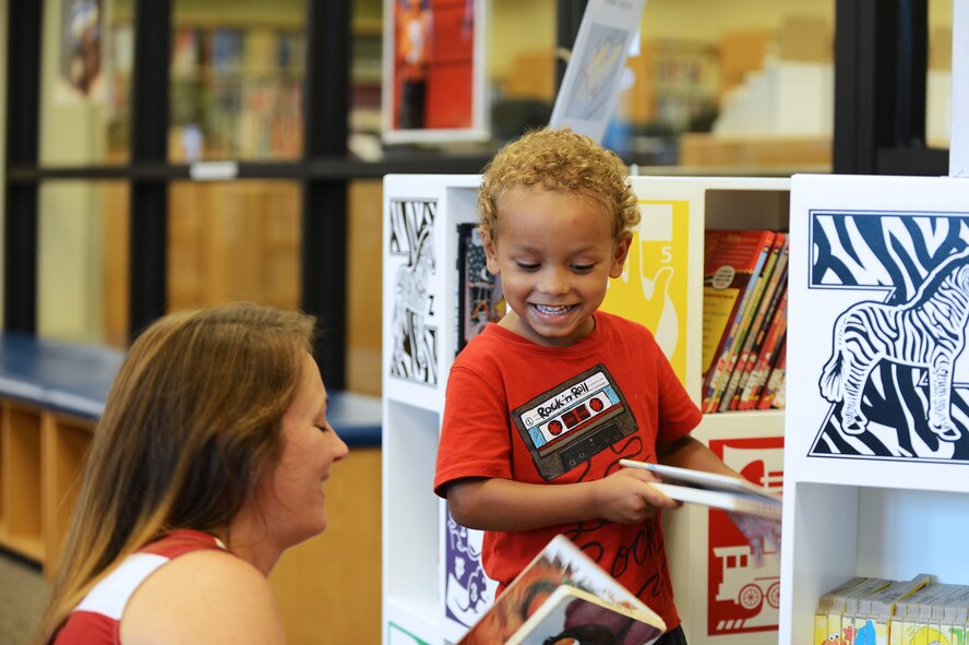 Nicole Cartledge (left) picks out books with her son Aiden in the McElveen Resource Center (library) at Shaw Air Force Base, S.C., July 31, 2013. Due to financial cutbacks Department of Defense wide, manning in the library and other facilities has been cut, which required active-duty services members to fulfill roles usually filled by contractors or civilians. (U.S. Air Force photo by Airman 1st Class Daniel Blackwell/Released)