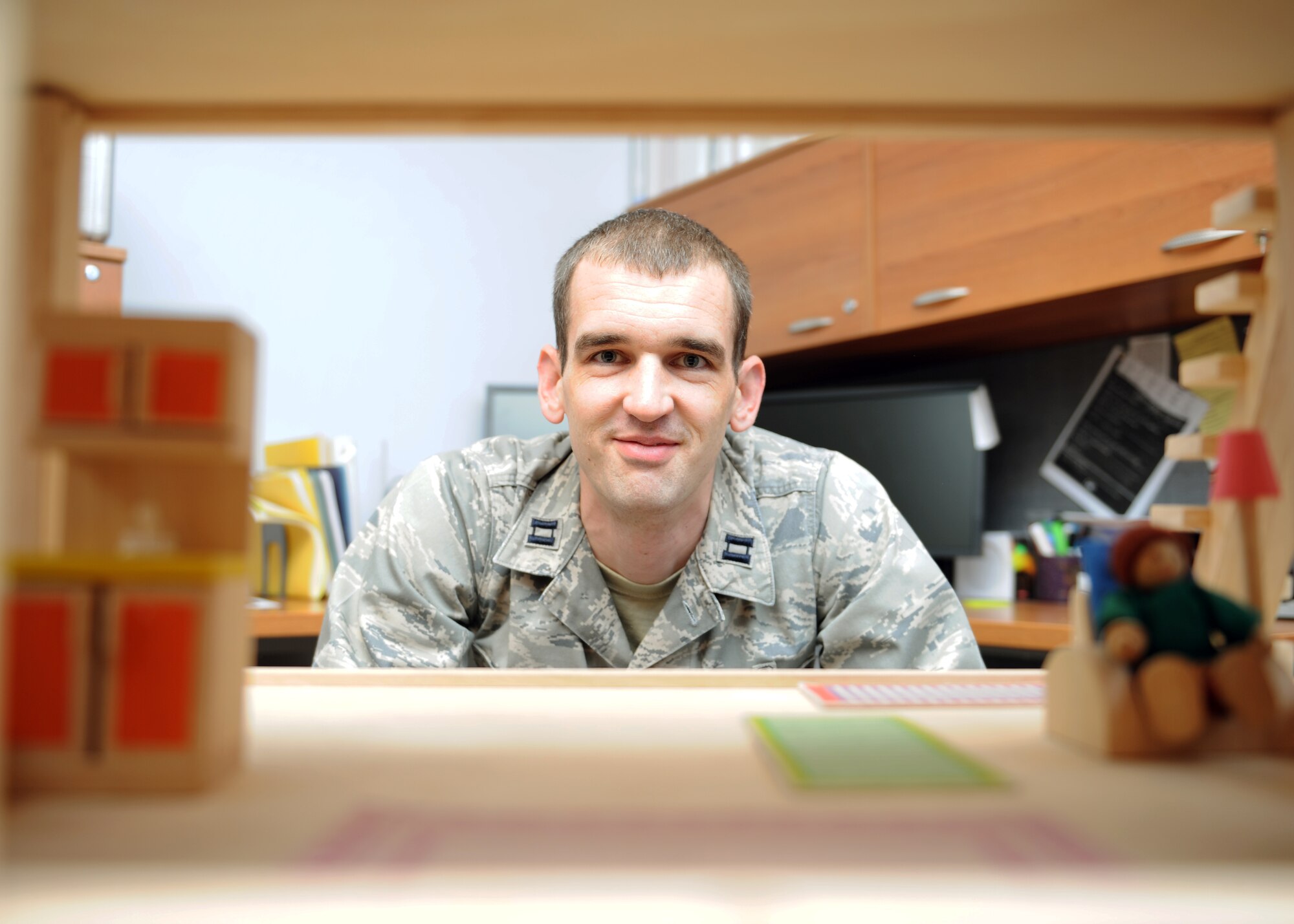 Capt. Michael Brunson, 39th Medical Operations Squadron pediatrician, peers through a dollhouse used for developmental education Aug.1, 2013, at Incirlik Air Base, Turkey. Brunson is also the Education and Development Intervention Services coordinator at Incirlik. (U.S Air Force photo by Senior Airman Chase Hedrick/Released)