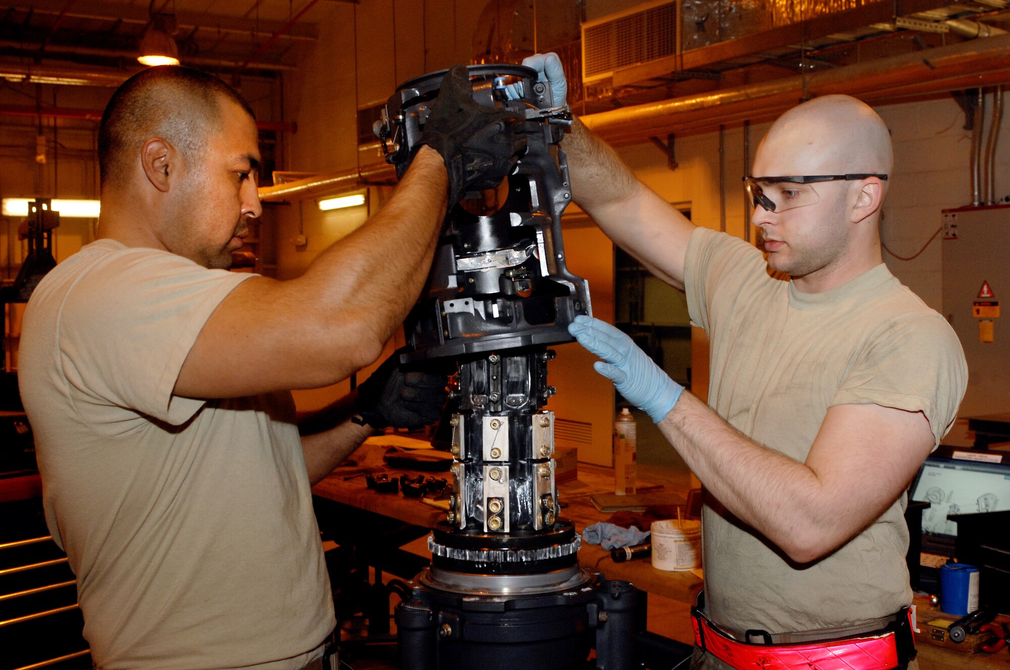 Staff Sgt. Eduardo Sera (left), 451st Expeditionary Maintenance Squadron armament back shop floor chief and Airman 1st Class Brandon Anderson (right), 451st Expeditionary Maintenance Squadron armament back shop combat technician, assemble part of an F-16 Fighting Falcon weapons system at Kandahar Airfield, Afghanistan July 26, 2013. Regular maintenance on aircraft weapons systems enables the wing to meet the air tasking order and provide close air support to NATO forces throughout Afghanistan. Anderson and Sera are stationed at Spangdahlem Air Base, Germany, and Anderson is a native of Asheville, N.C. (U.S. Air Force photo by Senior Airman Jack Sanders)
