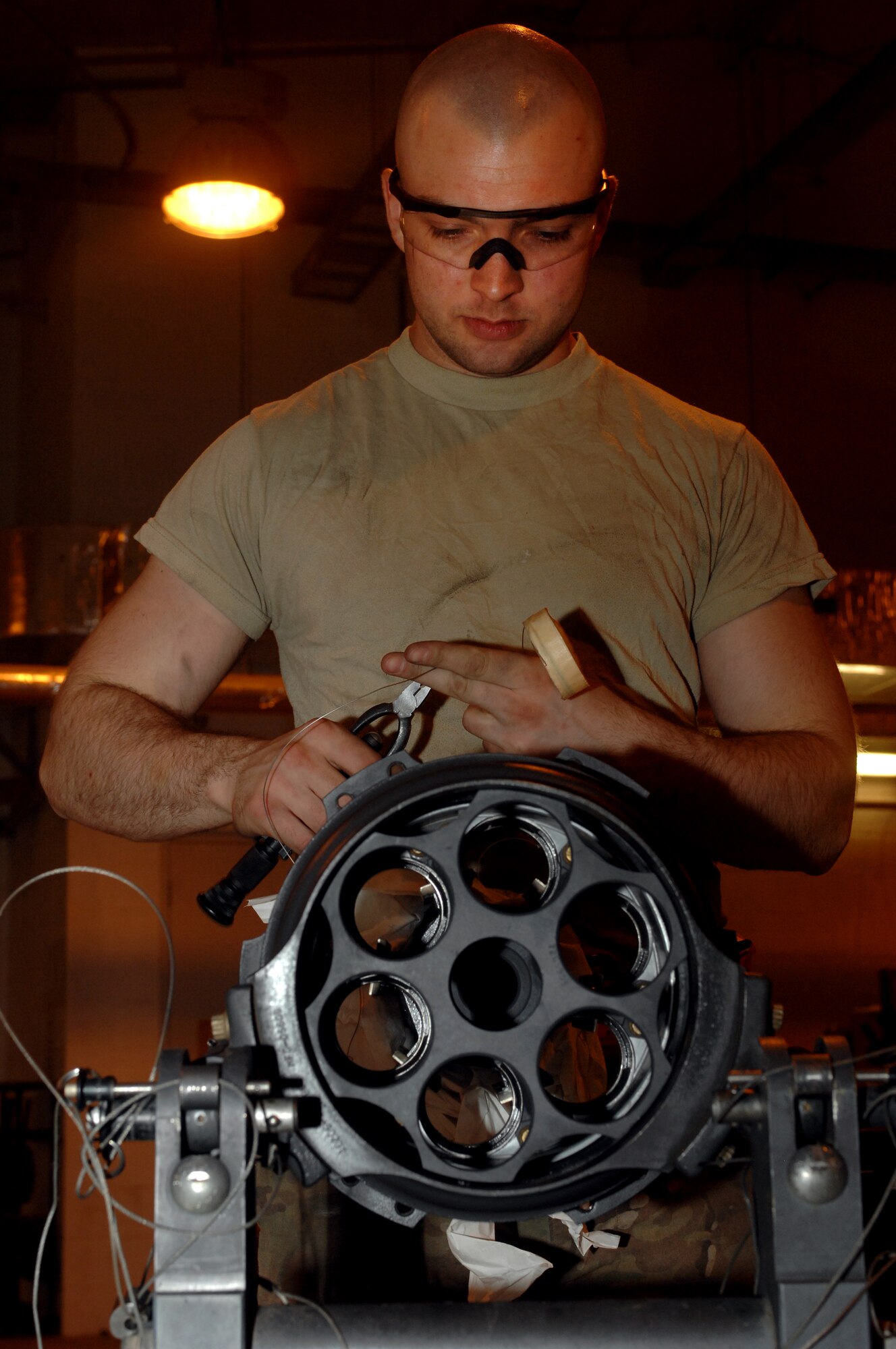Airman 1st Class Brandon Anderson, 451st Expeditionary Maintenance Squadron armament back shop combat technician, secures safety wire to part of an F-16 Fighting Falcon weapons system during reassembly at Kandahar Airfield, Afghanistan, July 26, 2013. Airmen conduct regular maintenance to enable the wing to continue to provide close air support to NATO forces throughout Afghanistan. Anderson is stationed at Spangdahlem Air Base, Germany, and is a native of Asheville, N.C. (U.S. Air Force photo by Senior Airman Jack Sanders)