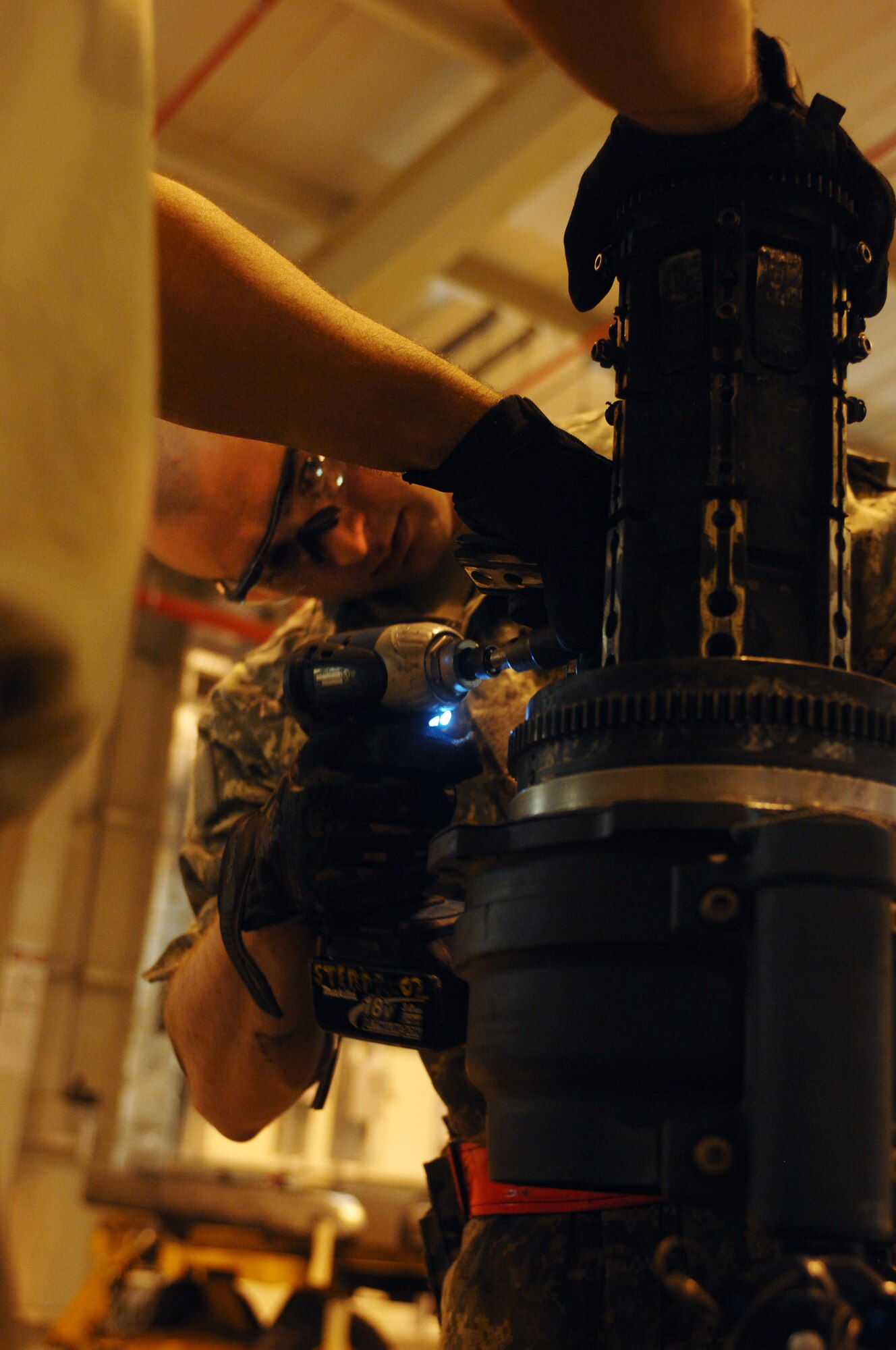 Staff Sgt. Eduardo Sera (left), 451st Expeditionary Maintenance Squadron armament back shop floor chief, holds a piece of an F-15 Fighting Falcon weapons system in place while Airman 1st Class Brandon Anderson (right), 451st Expeditionary Maintenance Squadron armament back shop combat technician, disassembles the system at Kandahar Airfield, Afghanistan, July 25, 2013. The F-16s based at KAF provide close air support to NATO forces throughout Afghanistan. Anderson and Sera are stationed at Spangdahlem Air Base, Germany, and Anderson is a native of Asheville, N.C. (U.S. Air Force photo by Senior Airman Jack Sanders)