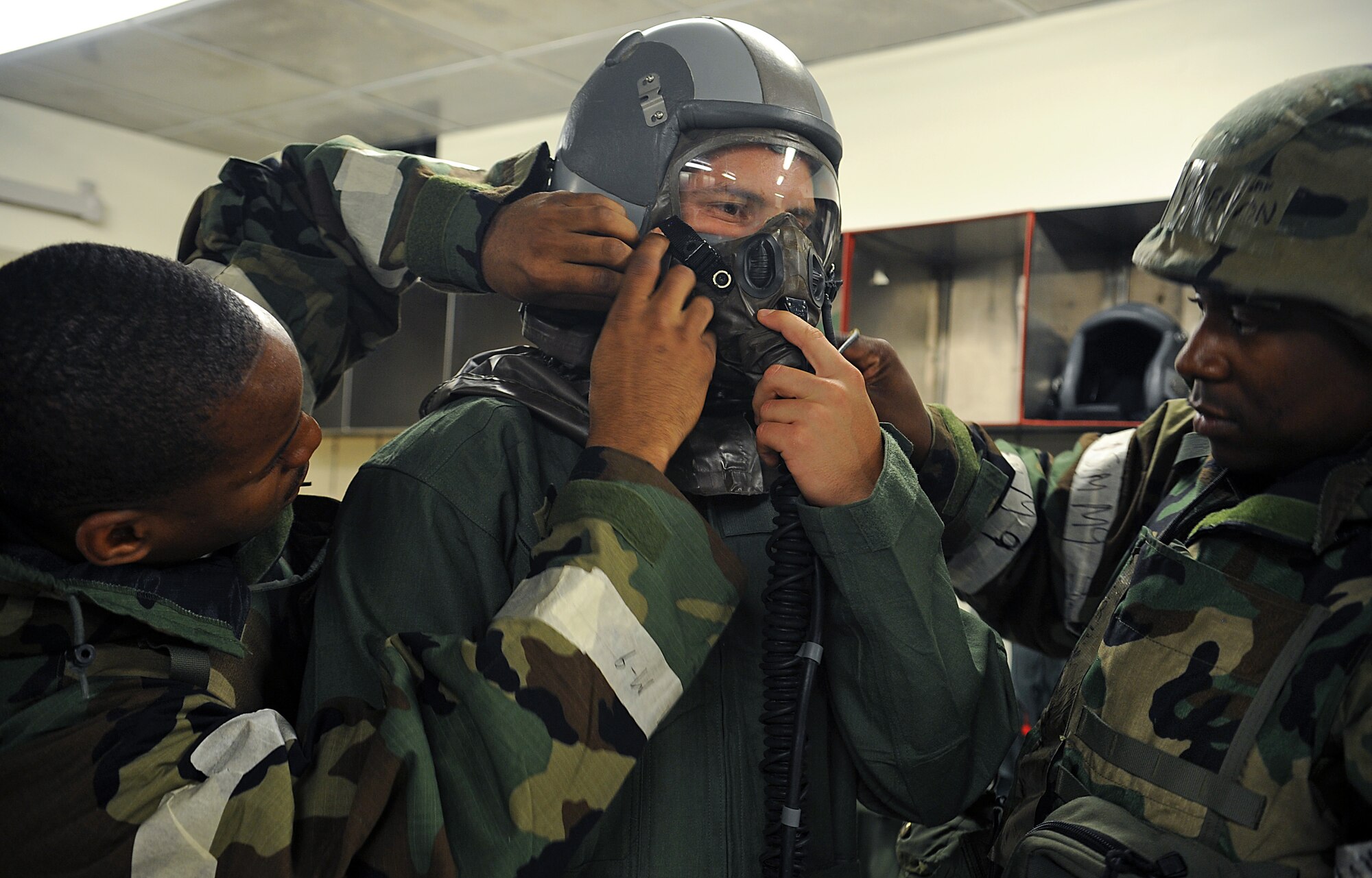 Airmen from the 51st Operations Support Squadron aircrew equipment flight help 1st Lt. Cale Lamoreux, 25th Fighter Squadron pilot, don Aircrew Eye and Respiratory Protection equipment during Operational Readiness Exercise Beverly Midnight 13-03, at Osan Air Base, Republic of Korea, Aug. 5, 2013. When AERP equipment is worn, the pilot must be helped to dress and be systematically "undressed" by AFE technicians. (U.S. Air Force photo/Staff Sgt. Sara Csurilla)