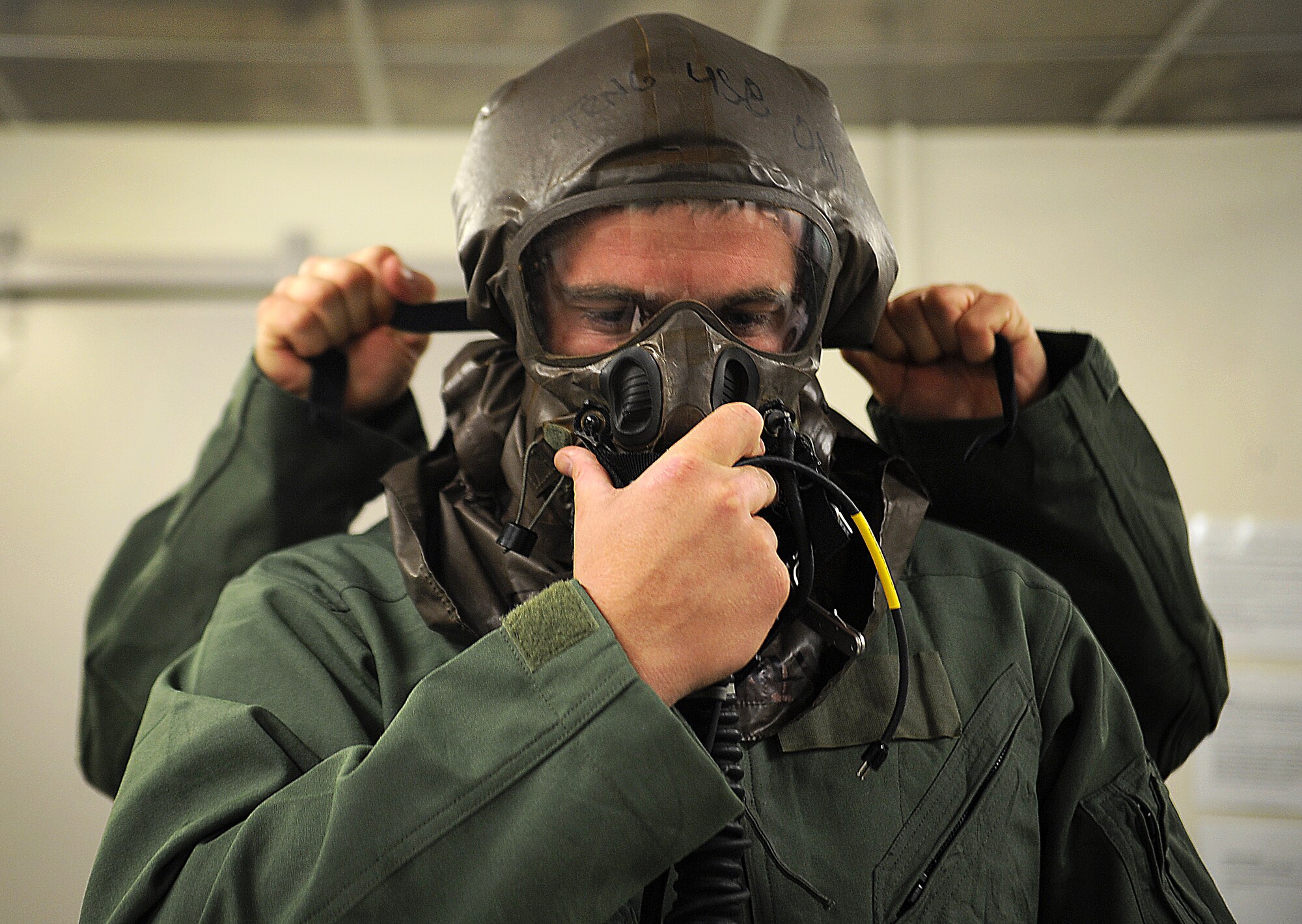 First Lt. Cale Lamoreux, 25th Fighter Squadron pilot, dons Aircrew Eye and Respiratory Protection equipment during Operational Readiness Exercise Beverly Midnight 13-03, at Osan Air Base, Republic of Korea, Aug. 5, 2013. Pilots from the 25th and 36th Fighter Squadrons practice wearing the AERP equipment during OREs to prepare themselves for a potential chemical, biological or radiological environment. (U.S. Air Force photo by Staff Sgt. Sara Csurilla)