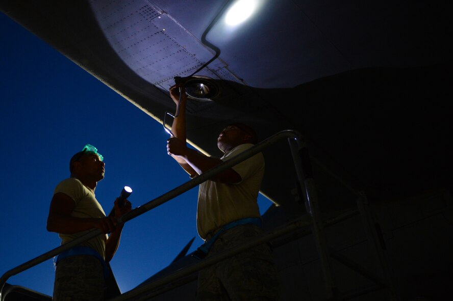(Right) Staff Sgt. Christian Wells, 86th Aircraft Maintenance Squadron flying crew chief, and (Left) Senior Airman Floyd Harrison-Sowell, 86th AMXS dedicated crew chief, replace a landing light assembly on a C-130J Super Hercules, July 29, 2013, Ramstein Air Base, Germany. 86th AMXS Airmen ensure all assigned aircraft are 100 percent combat ready prior to take off. (U.S. Air Force photo/Senior Airman Caitlin Guinazu)