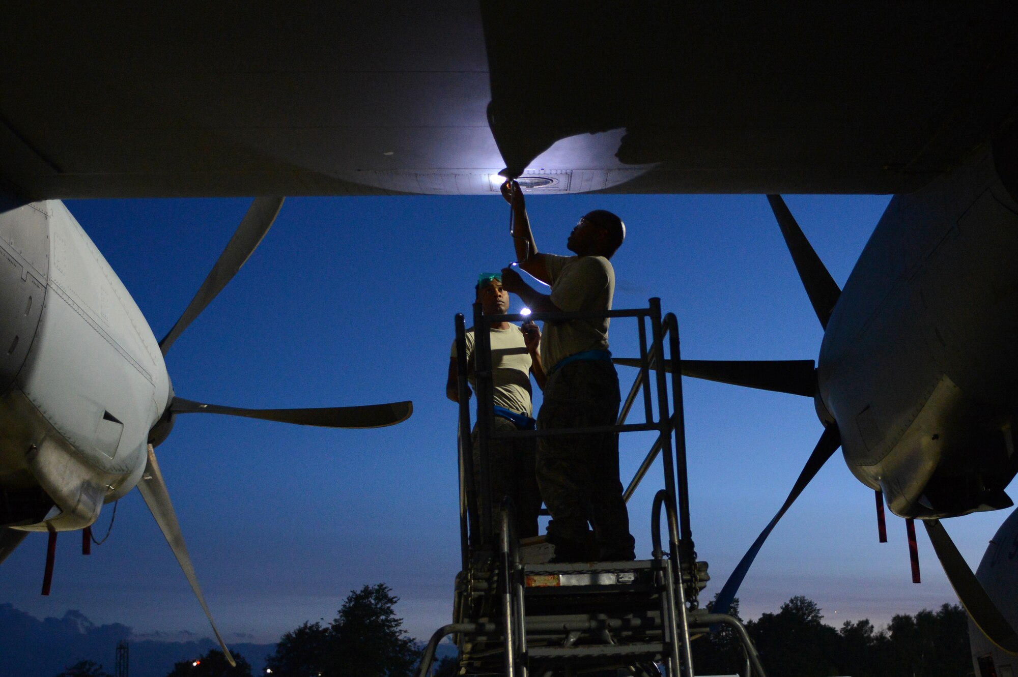 Staff Sgt. Christian Wells, 86th Aircraft Maintenance Squadron flying crew chief, and Senior Airman Floyd Harrison-Sowell, 86th AMXS dedicated crew chief, replace a landing light assembly on a C-130J Super Hercules, July 29, 2013, Ramstein Air Base, Germany. 86th AMXS Airmen ensure all assigned aircraft are 100 percent combat ready prior to take off. (U.S. Air Force photo/Senior Airman Caitlin Guinazu)