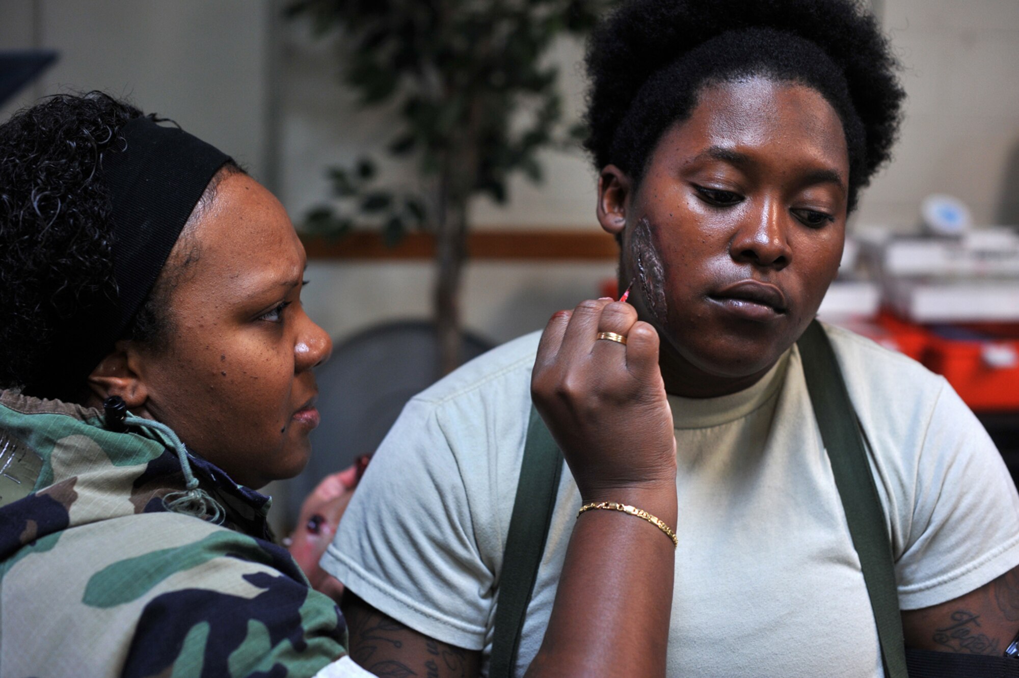 Tech. Sgt. Latisha Barnette, 51st Medical Support Squadron medical systems flight chief, uses moulage equipment to paint a simulated wound on Senior Airman Shannon Walker, 51st Logistics Readiness Squadron material management member, during Operational Readiness Exercise Beverly Bulldog 13-03 at Osan Air Base, Republic of Korea, Aug. 6, 2013. Moulage provides a sense of realism in exercises to ensure that medics and first responders are prepared to react to a real world accident or emergency. (U.S. Air Force photo/Senior Airman Kristina Overton) 