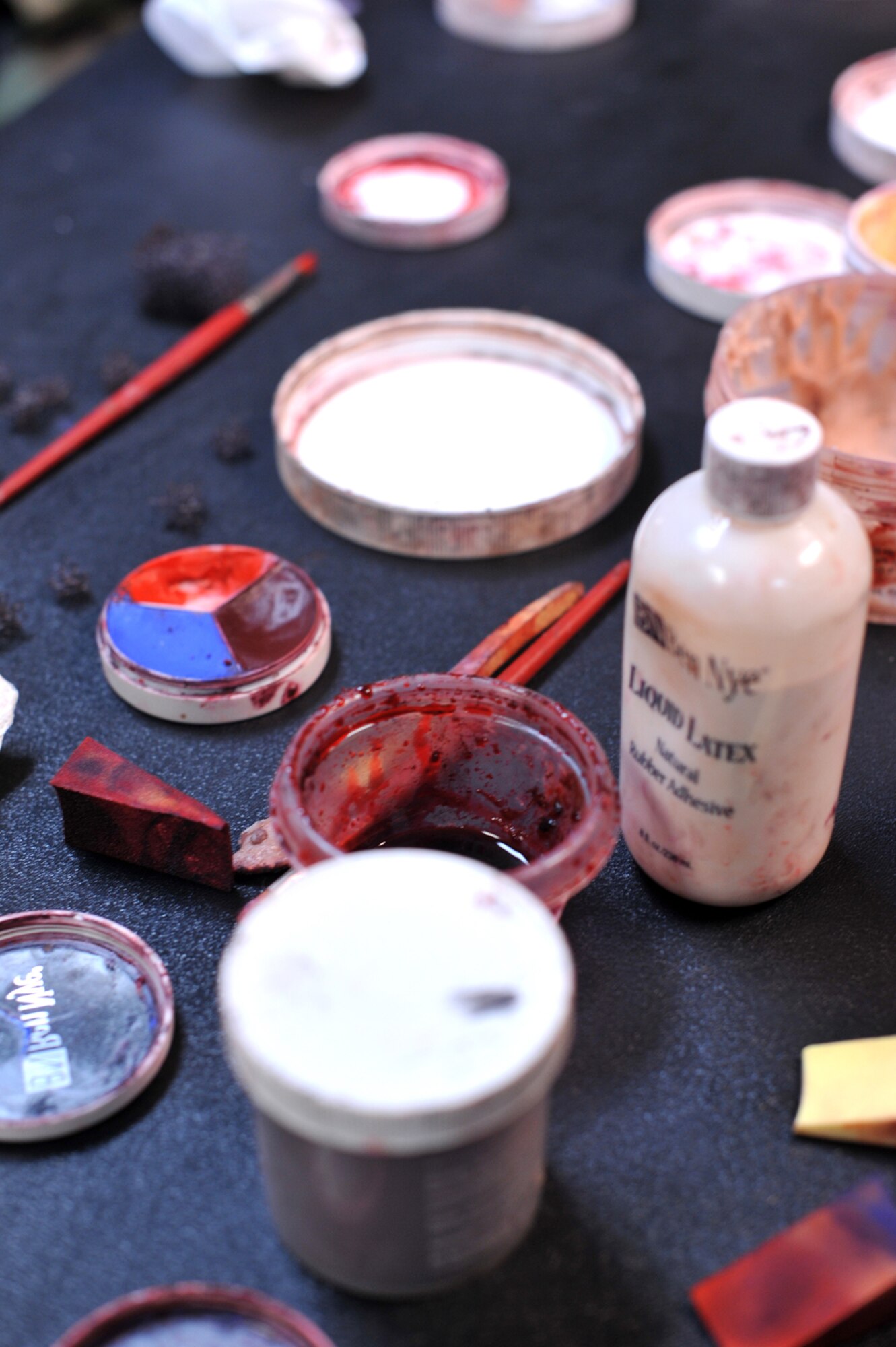 Make-up used to apply moulage to mock patients is set aside as members from the 51st Medical Group apply fake wounds on Airmen during Operational Readiness Exercise Beverly Midnight 13-03 at Osan Air Base, Republic of Korea, Aug. 6, 2013. Moulage victims are used to help Airmen and medical professionals better learn how to give proper medical treatment after simulated attacks on the base. (U.S. Air Force photo/Senior Airman Kristina Overton)