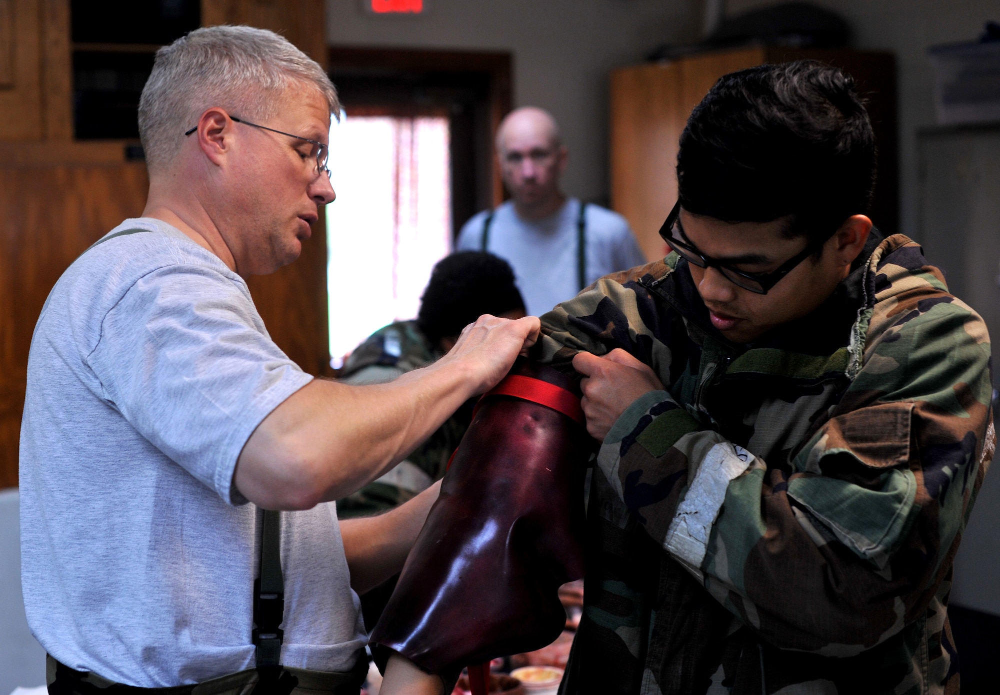 Senior Master Sgt. Paul Hagarty, 51st Aerospace Medicine Squadron superintendent, helps secure a fake wound onto the arm of Airman 1st Class Jerry Inthavongsa, 51st Communications Squadron client systems specialist, for a simulated mass casualty during Beverly Midnight 13-03 at Osan Air Base, Republic of Korea, Aug. 6, 2013. Members from the 51st Medical Group apply moulage to mock victims every exercise to help Airmen and medical professionals better learn how to give proper medical treatment. (U.S. Air Force photo/Senior Airman Kristina Overton)