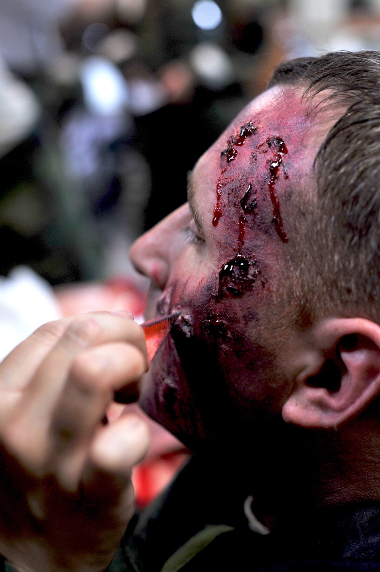 Staff Sgt. Christopher Osterholm, 51st Munitions Squadron armament technical supervisor, acts as a role player for a mass casualty simulation during Beverly Bulldog 13-03, Aug. 6, 2013. Osterholm was injured in a simulated attack and was given several cuts and lacerations on his face. (U.S. Air Force photo/Senior Airman Kristina Overton)