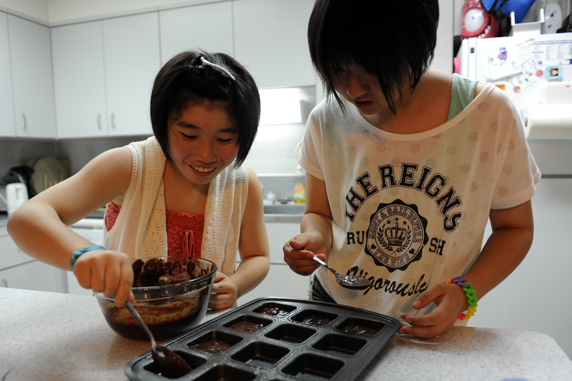 Amane Nakamura, left, and Nanase Abe, students from Tanohata Junior High School, make brownies during a weekend Homestay event at Misawa Air Base, Japan, Aug. 3, 2013. Homestay is a program sponsored by the Misawa International Club where Japanese local nationals are invited to stay with military families for a weekend to experience one another's culture. (U.S. Air Force photo by Senior Airman Kia Atkins)