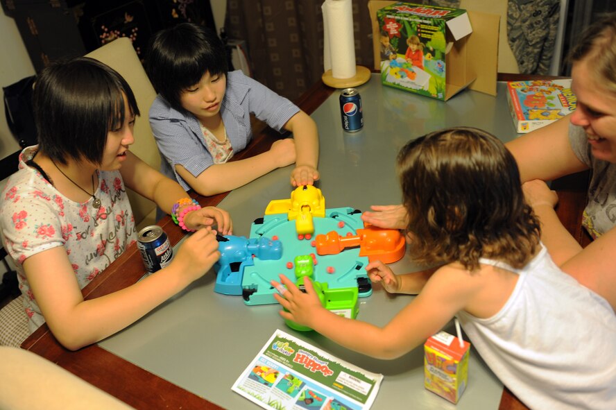 Nanase Abe and Amane Nakamura, left, students from Tanohata Junior High School, play a game with U.S. Air Force Tech. Sgt. Marie Brown, 35th Fighter Wing Public Affairs NCO in charge of U.S. media relations, and her daughter during a weekend Homestay event at Misawa Air Base, Japan, Aug. 2, 2013. Brown was one of four military families who hosted eight Japanese students from Tanohata Junior High School in Tanohata, Japan, in an effort to share cultural traditions and demonstrate continued U.S. support to a community that endured severe natural disasters two years ago. (U.S. Air Force photo by Senior Airman Kia Atkins)