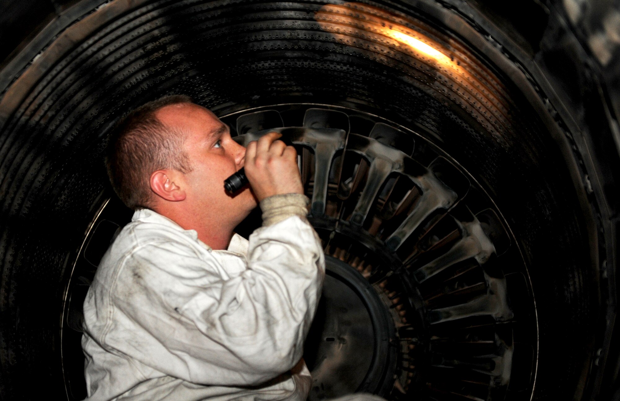 U.S. Air Force Staff Sgt. James Morris, 14th Aircraft Maintenance Unit crew chief, inspects the exhaust of an F-16 Fighting Falcon at Misawa Air Base, Japan, Aug. 1, 2013. Morris performed post-flight inspection for any cracks or broken parts inside the exhaust that could compromise the safety of the aircraft. (U.S. Air Force photo by Senior Airman Kia Atkins)