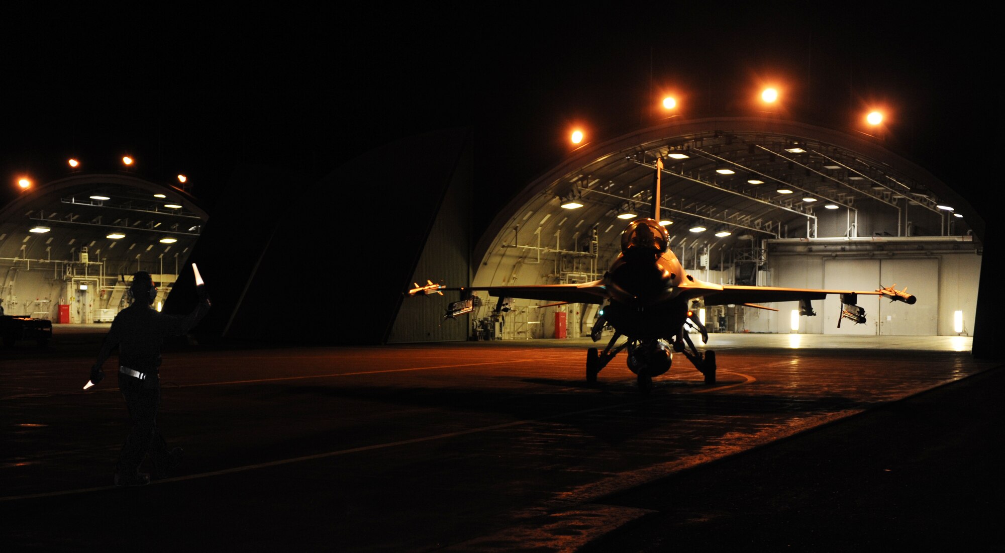 U.S. Air Force Staff Sgt. William Wilkins, 14th Aircraft Maintenance Unit crew chief, marshals Capt. Matthew Kimmel, 14th Fighter Squadron pilot, into place at Misawa Air Base, Japan, Aug. 1, 2013. All week long, the 35th Maintenance Group had been taking part in Combat Shield, an operation responsible for assisting commanders in assessing the unit's level of electronic warfare readiness. (U.S. Air Force photo by Senior Airman Kia Atkins)