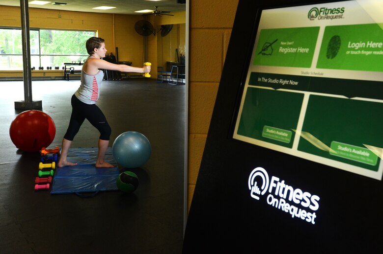 Addison Johnson, wife of Airman 1st Class Jensen Stidham, watches a “Fitness on Request” video while exercising at the fitness center, Shaw Air Force Base S.C., Aug. 1, 2013.  The new program at the fitness center “Fitness on Request” offers a unique twist on a personal trainer. (U.S. Air Force photo by Airman 1st Class Jensen Stidham/ Released) 