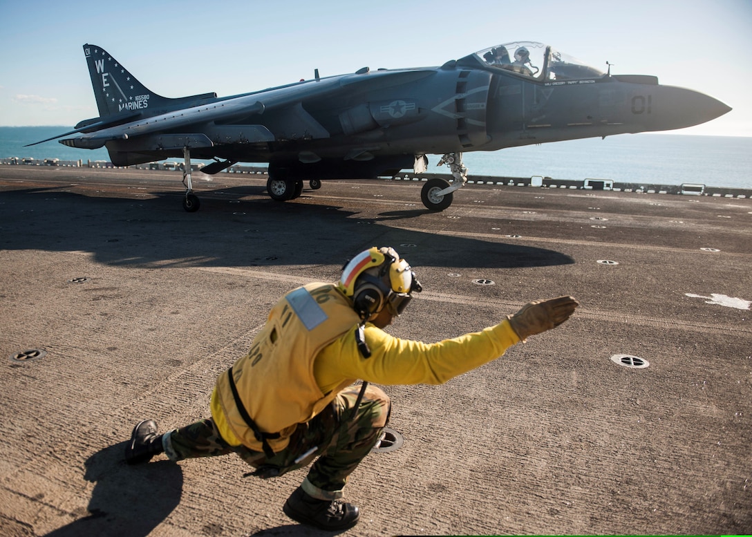 U.S. Navy Aviation Boatswain's Mate (Handling) 1st Class Jawara Lockett signals the pilot of a U.S. Marine Corps AV-8B Harrier aircraft assigned to Marine Attack Squadron (VMA) 214 that he is cleared for launch from the flight deck of the amphibious assault ship USS Bonhomme Richard (LHD 6) in the Coral Sea, Aug. 4, 2013. The Bonhomme Richard was the flagship of the Bonhomme Richard Amphibious Ready Group and, with the embarked 31st Marine Expeditionary Unit, conducted routine joint force operations in the U.S. 7th Fleet area of operations. (DoD photo by Mass Communication Specialist Seaman Apprentice Edward Guttierrez III, U.S. Navy/Released)