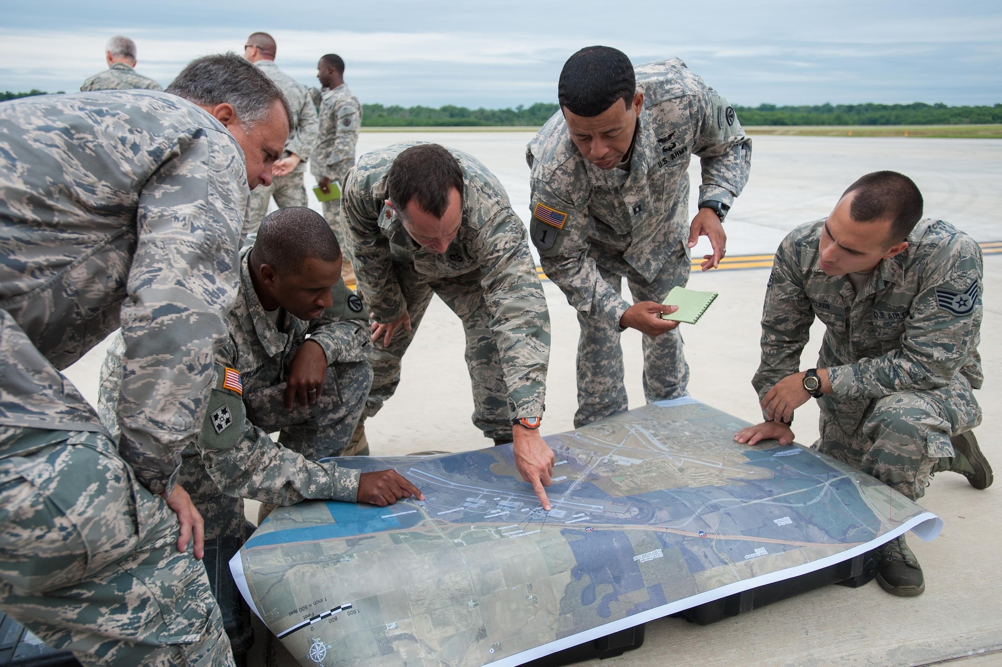Airmen from the Kentucky Air National Guard’s 123rd Contingency Response Group and Soldiers from the U.S. Army’s active-duty 689th Rapid Port Opening Element from Fort Eustis, Va., examine a map to determine the placement of disaster-response facilities at MidAmerica St. Louis Airport in Mascoutah, Ill., on Aug. 5, 2013, as part of Exercise Gateway Relief, a U.S. Transportation Command-directed earthquake-response scenario. The two units are joining forces to stand up and operate a Joint Task Force-Port Opening, which combines an Air Force Aerial Port of Debarkation with an Army trucking and distribution unit. The aerial port ensures the smooth flow of cargo and relief supplies into affected areas by airlift, while the trucking unit facilitates their final distribution over land. 