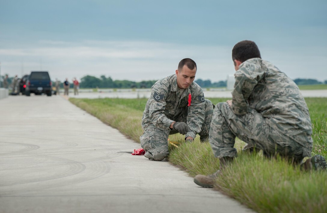 Staff Sgt. Beau DeLeon (left), a civil engineer from the New Jersey Air National Guard’s 108th Contingency Response Group, and Maj. Greg Schanding of the Kentucky Air National Guard’s 123rd Contingency Response Group, mark the layout of a tent city at MidAmerica St. Louis Airport in Mascoutah, Ill., on Aug. 5, 2013, as part of Exercise Gateway Relief, a U.S. Transportation Command-directed earthquake-response scenario. The 123rd is joining forces with the U.S. Army’s active-duty 689th Rapid Port Opening Element from Fort Eustis, Va., to stand up and operate a Joint Task Force-Port Opening, which combines an Air Force Aerial Port of Debarkation with an Army trucking and distribution unit. The aerial port ensures the smooth flow of cargo and relief supplies into affected areas by airlift, while the trucking unit facilitates their final distribution over land. 