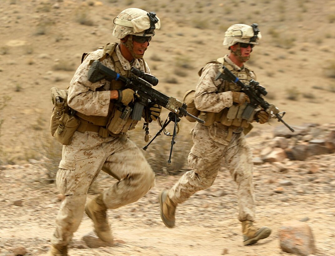 Marines with 1st Battalion, 9th Marines, 8th Marine Regiment, run for cover as they advance through Range 401 during a company-sized attack July 26.Marines run for cover as they advance through Range 401 during a company-sized attack July 26.