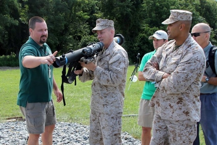 Brian McConnell (left), of Naval Surface Warfare Center Dahlgren, talks with Col. Michael Manning (holding weapon) and Lt. Col. Luis Lara about the new modular ballistic sight that has been added to the Shoulder-launched Multipurpose Assault Weapon, or SMAW. McConnell is the SMAW lead engineer at NSWCDD, Manning is Marine Corps Systems Command’s program manager for Infantry Weapons Systems, and Lara is the product manager for Anti-Armor Systems. 