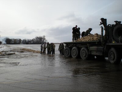 Soldiers from Battery A, 1st Battalion 147th Field Artillery of the South Dakota Army National Guard, perform sandbagging operations on Thursday, March 26 along Brown County Highway 14 to help stop flooding waters from flowing into Moccasin Creek.