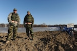 Pfc. Jess Krantz (left) and Spc. Eric Peters, both of Watertown, S.D., and members of the 139th Brigade Support Battalion of the South Dakota Army National Guard, patrol the dike to check the water level and look for weak spots on Saturday, March 28, 2009.
