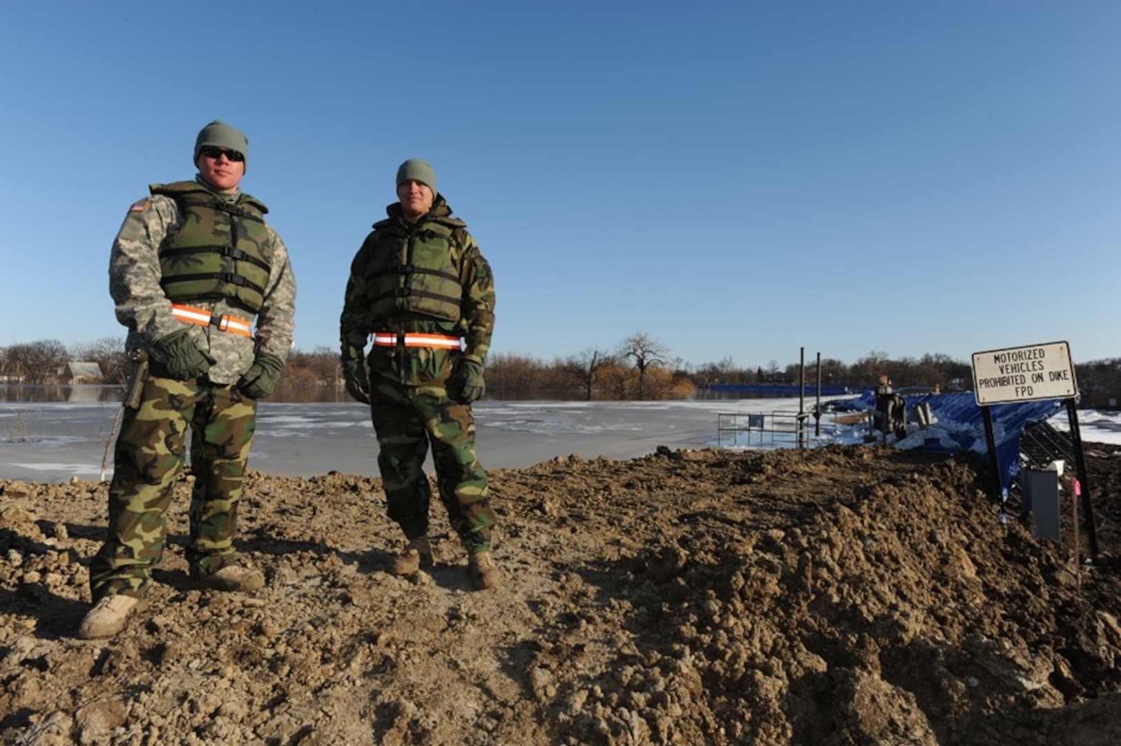 Pfc. Jess Krantz (left) and Spc. Eric Peters, both of Watertown, S.D., and members of the 139th Brigade Support Battalion of the South Dakota Army National Guard, patrol the dike to check the water level and look for weak spots on Saturday, March 28, 2009.
